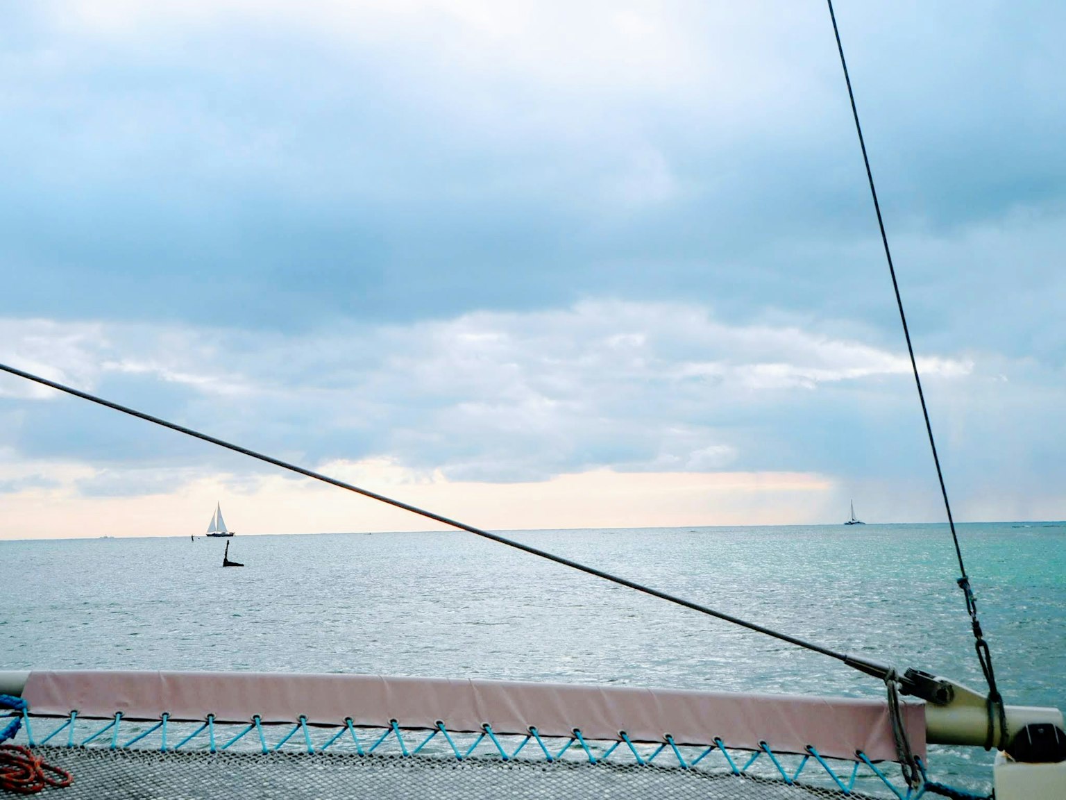 Pemandangan laut dengan yacht berlayar di cakrawala di bawah langit mendung