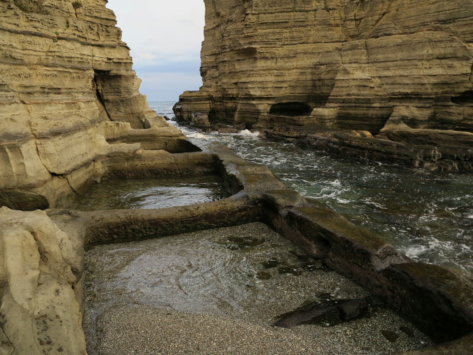 Rivière coulant entre des formations rocheuses avec plage de sable