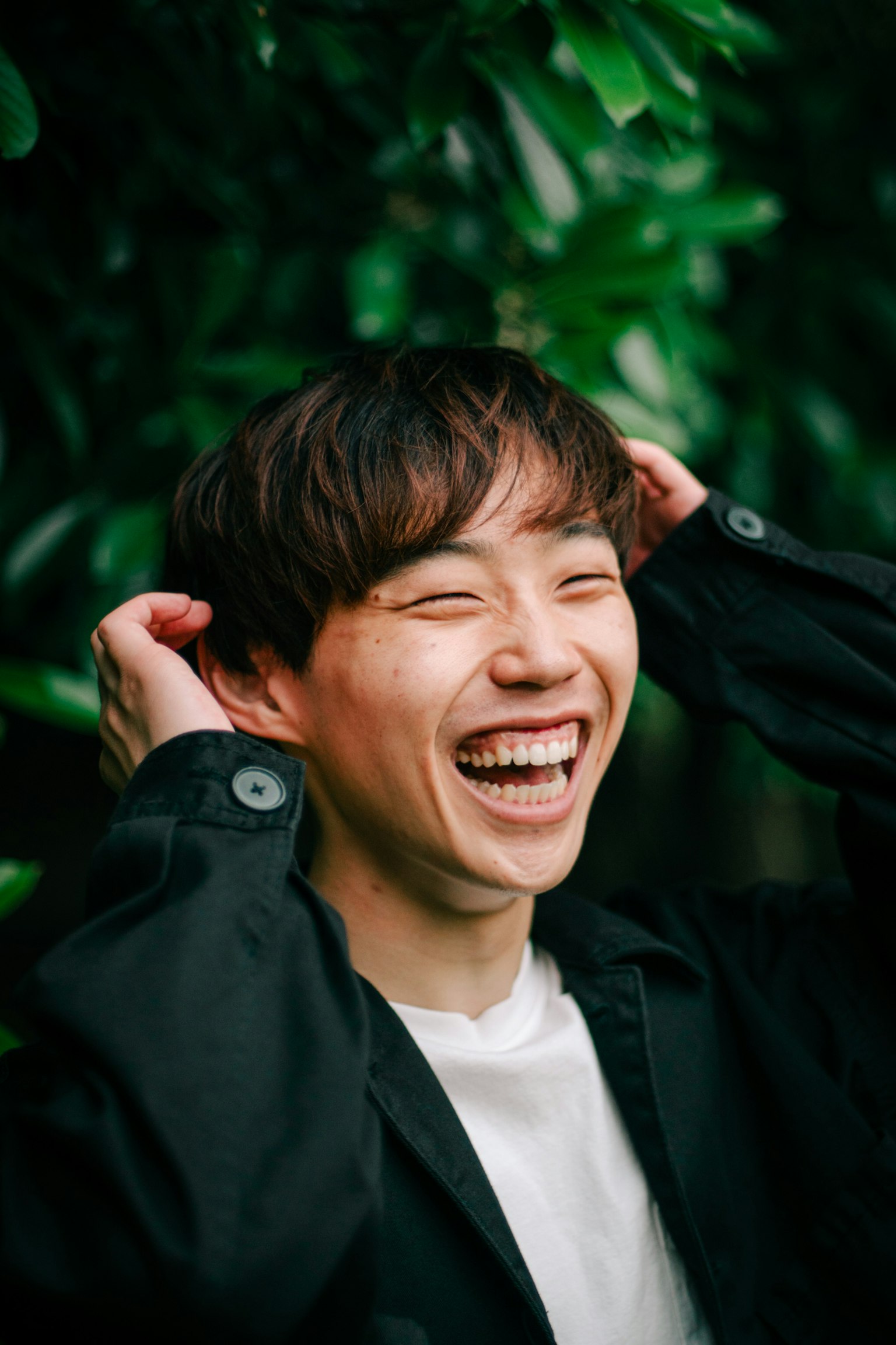ภาพถ่ายของชายหนุ่มยิ้มอยู่หน้าพืชใบเขียว