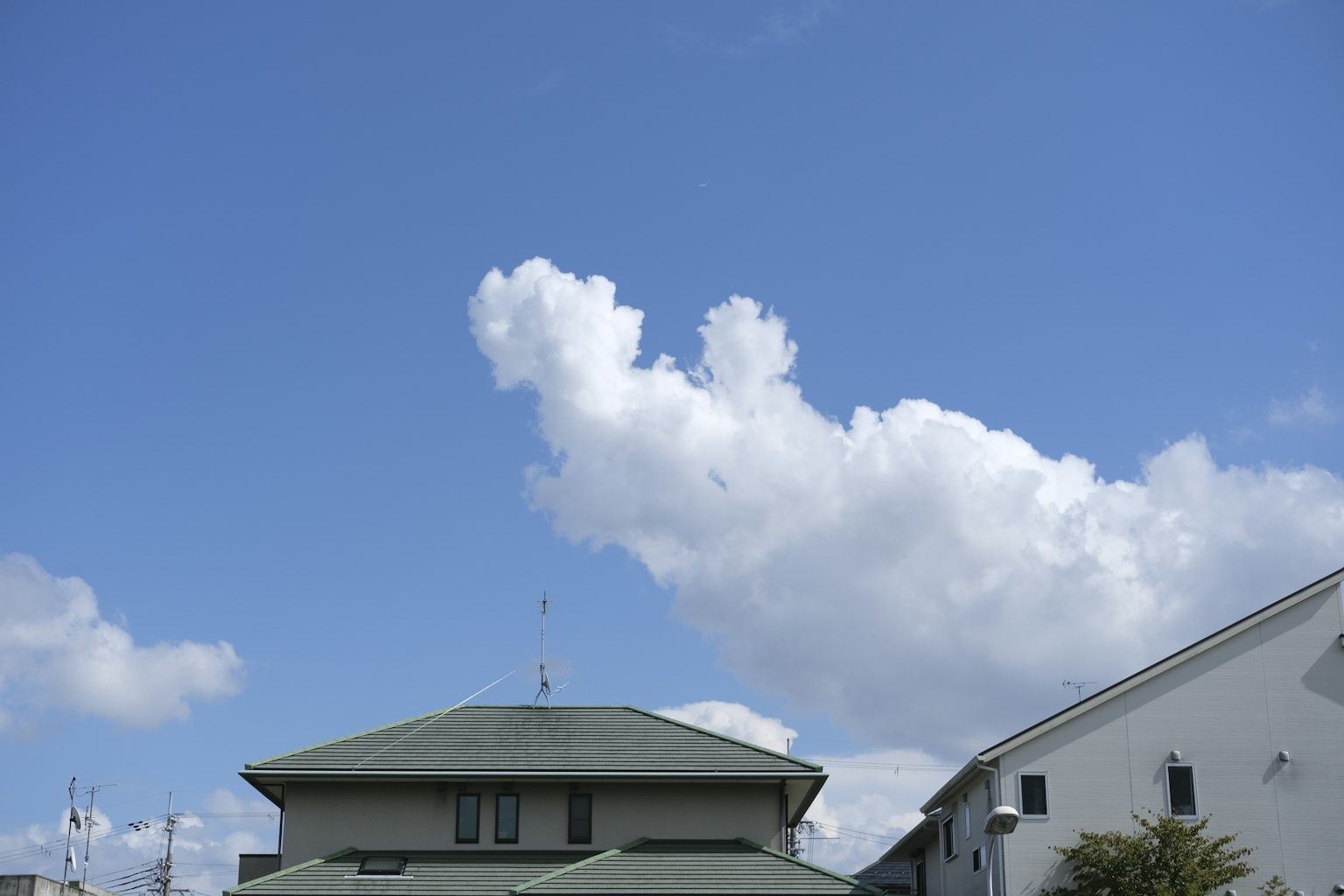 晴朗的藍天和屋頂上方的蓬鬆白雲