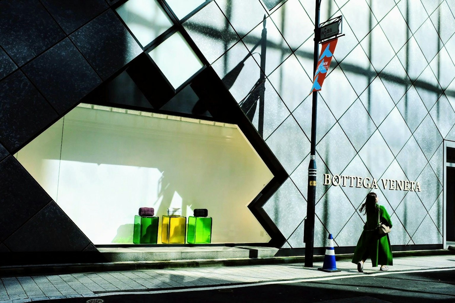 Modern architectural facade of Louis Vuitton store featuring colorful products in the window