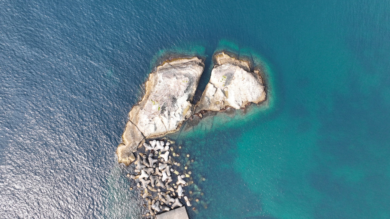 Vista aerea di una piccola isola rocciosa circondata da acque turchesi
