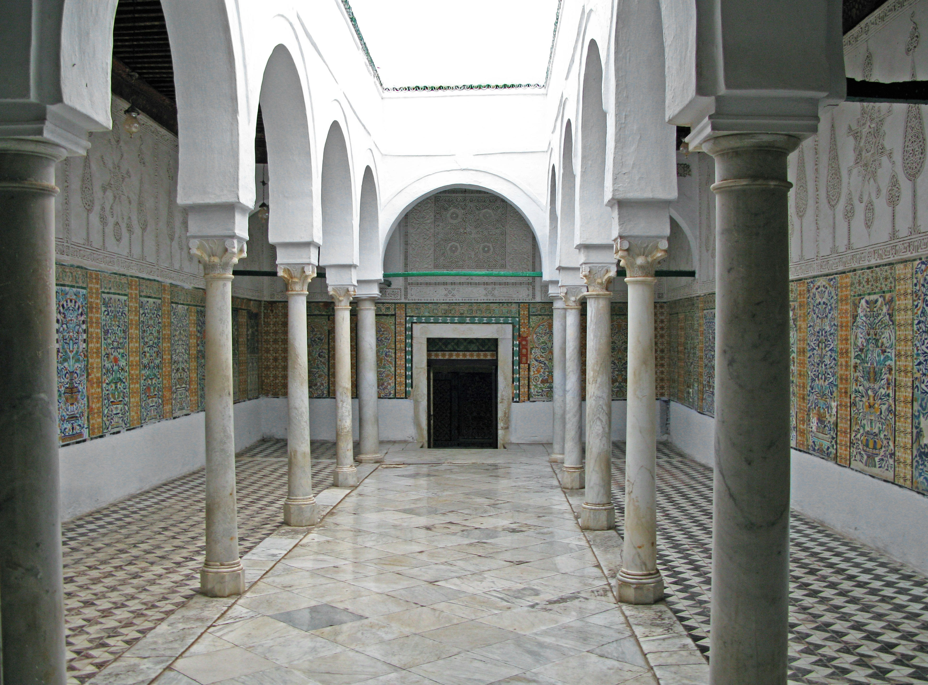 stone-paved courtyard arcade with arches and columns
