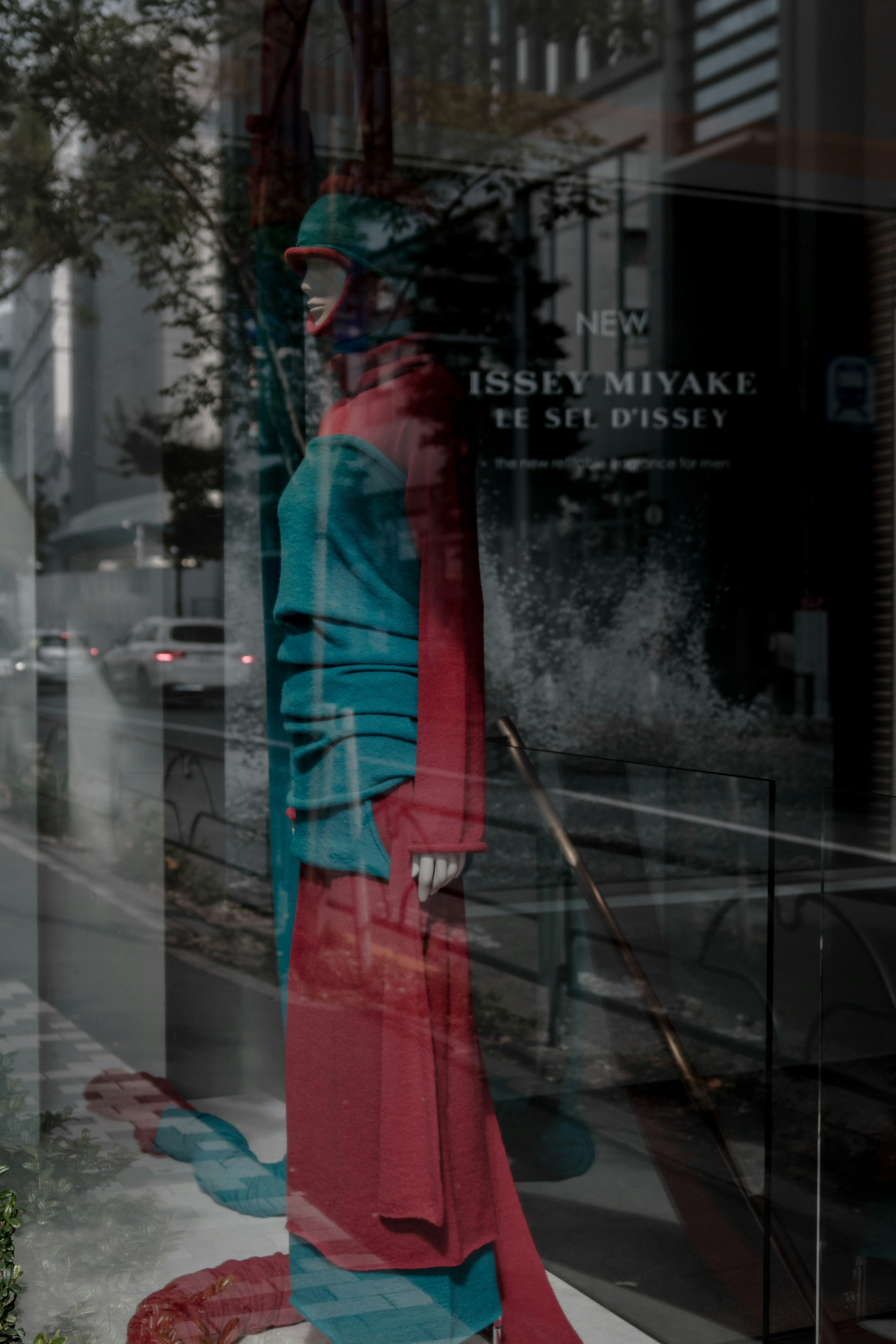 青と赤の衣装が重なって見えるISSEY MIYAKEの店先のようなショーウィンドウ画像