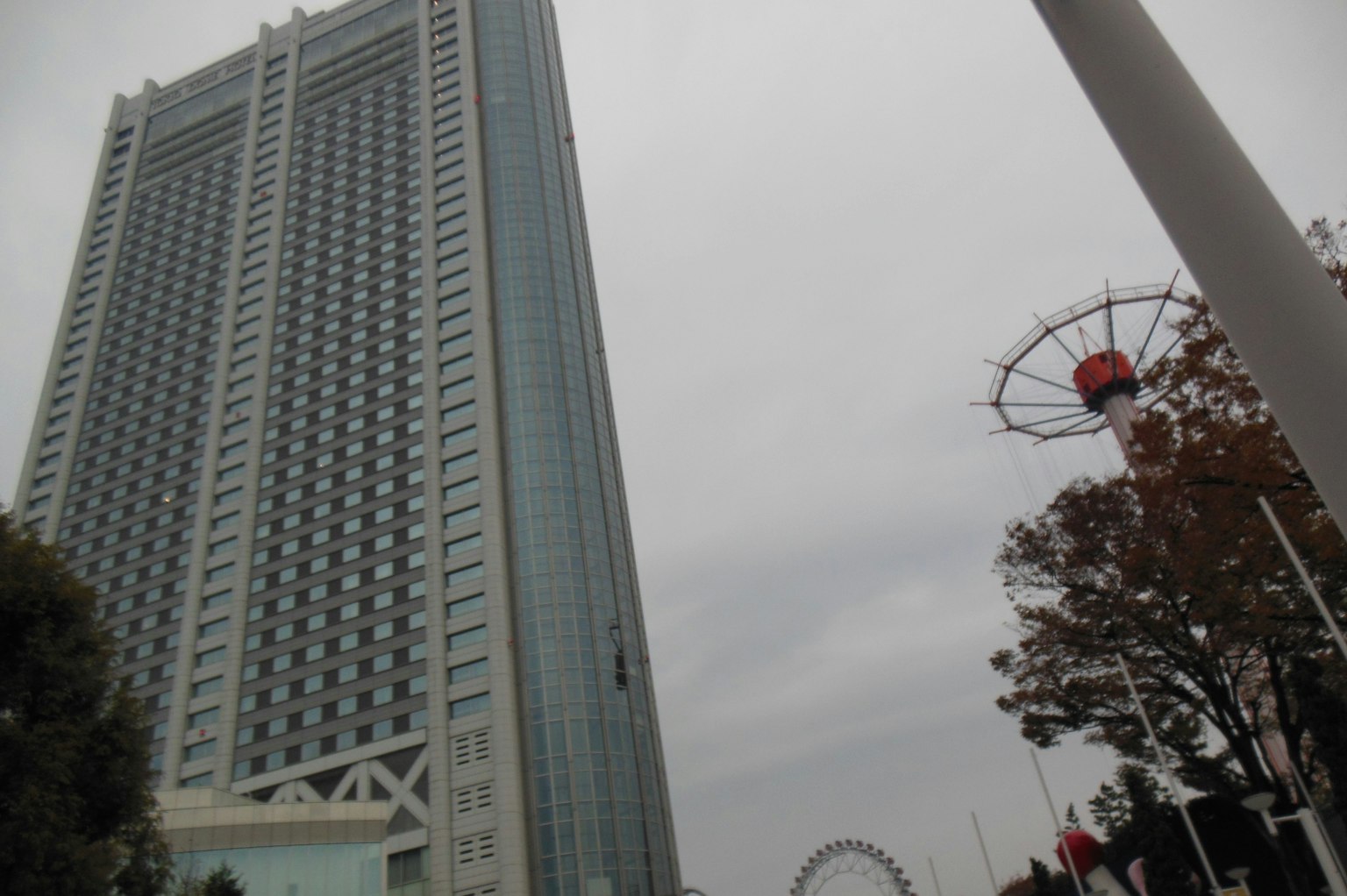 Vue d'un gratte-ciel avec une grande roue en arrière-plan