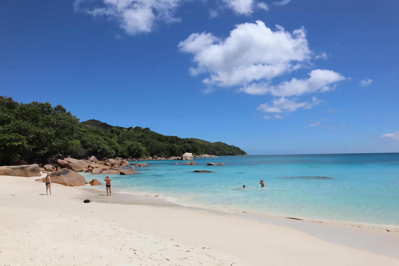 Hermosa escena de playa con océano azul y arena blanca personas disfrutando del agua