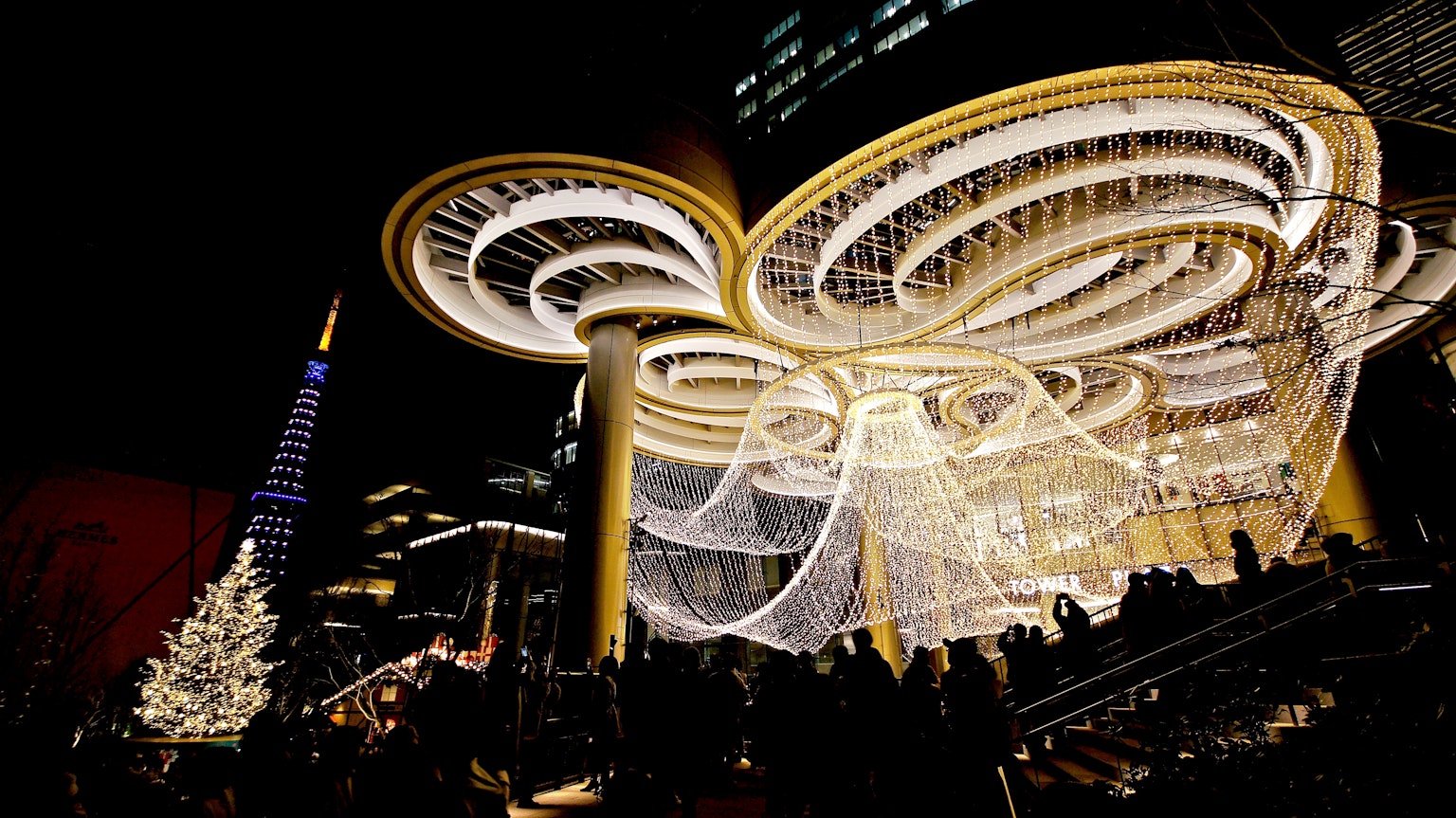 A stunning nighttime cityscape featuring an elegant chandelier and a Christmas tree