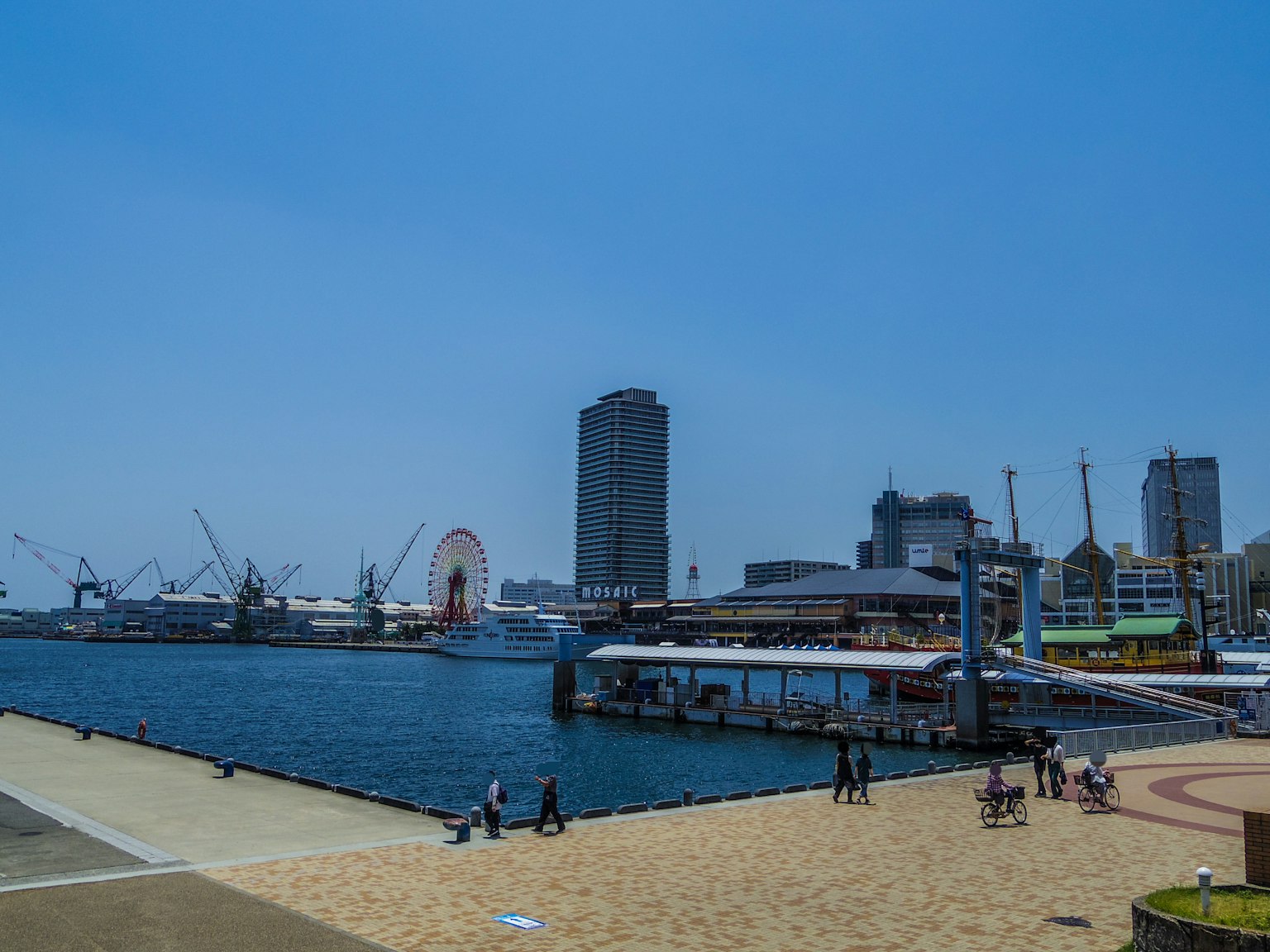 Vue du port sous un ciel bleu avec des gratte-ciels et une promenade sablonneuse