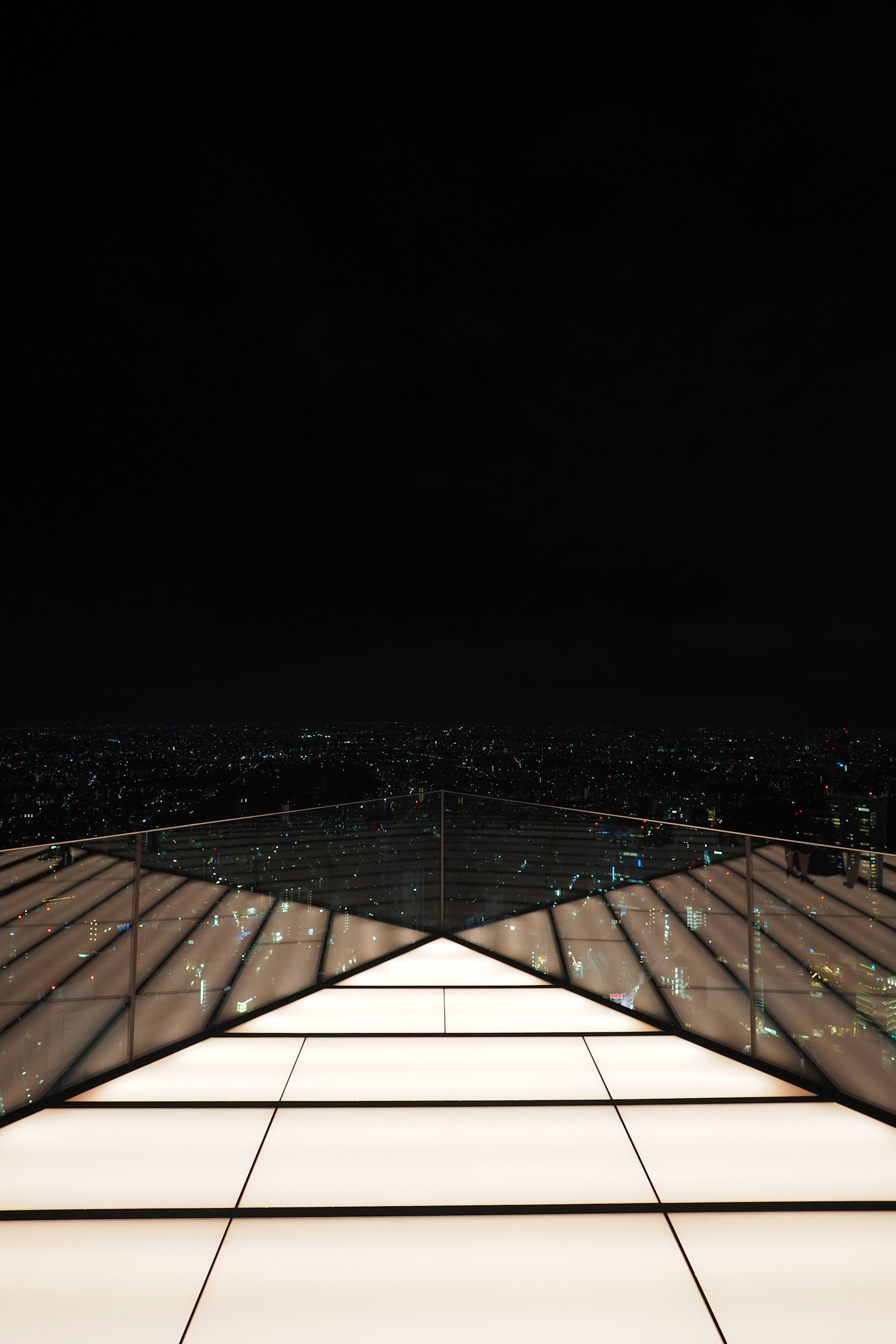 Glass balcony overlooking a beautiful city skyline at night