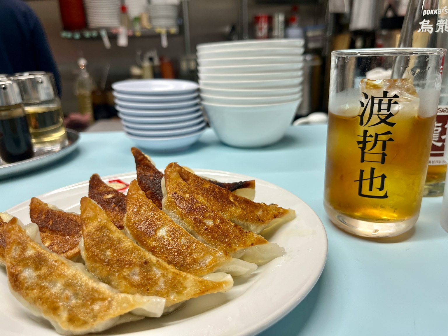 一餐场景，特色饺子和啤酒，白盘上的煎饺和玻璃里的饮料