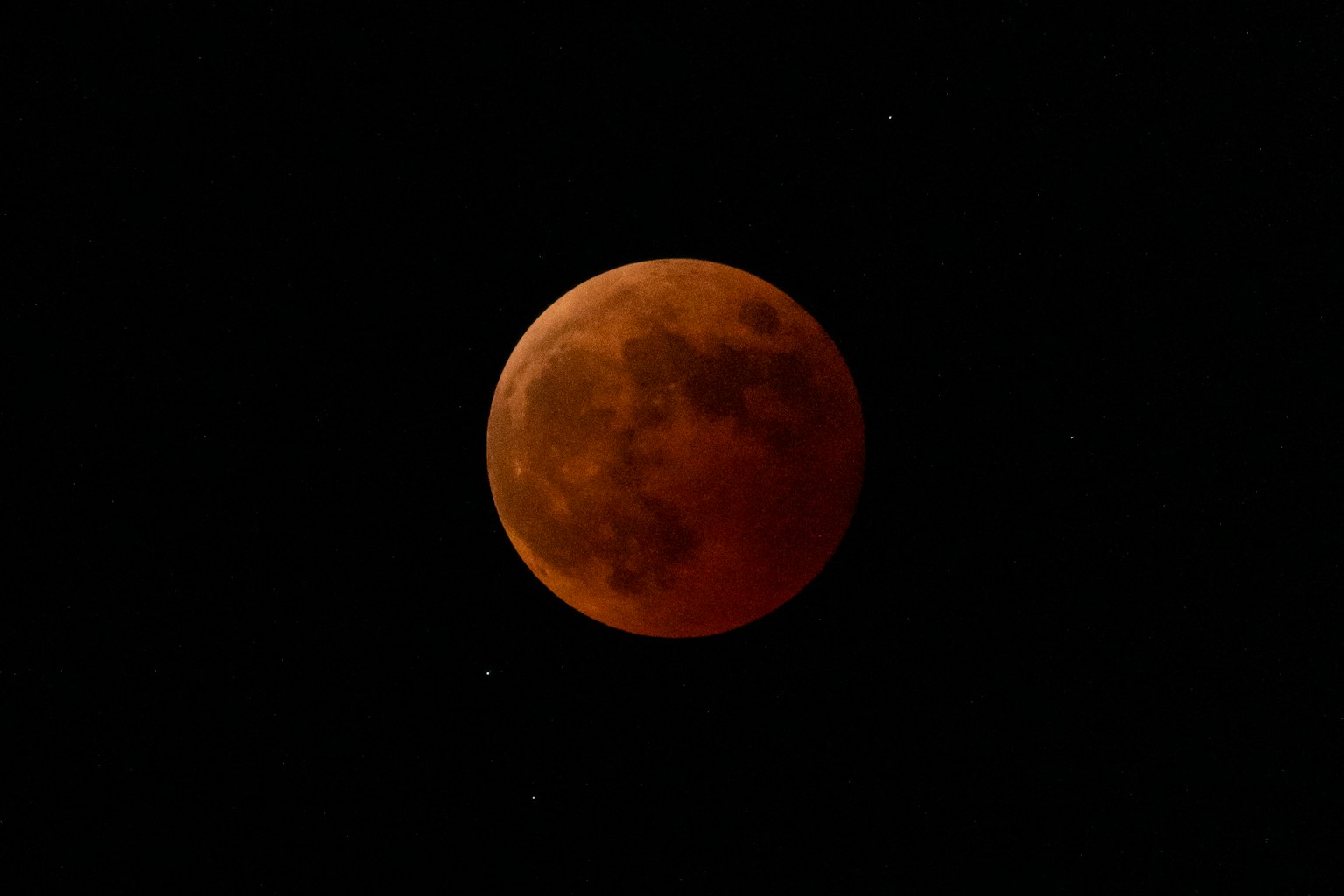 Stupendo fenomeno celeste con una luna rossa su sfondo nero