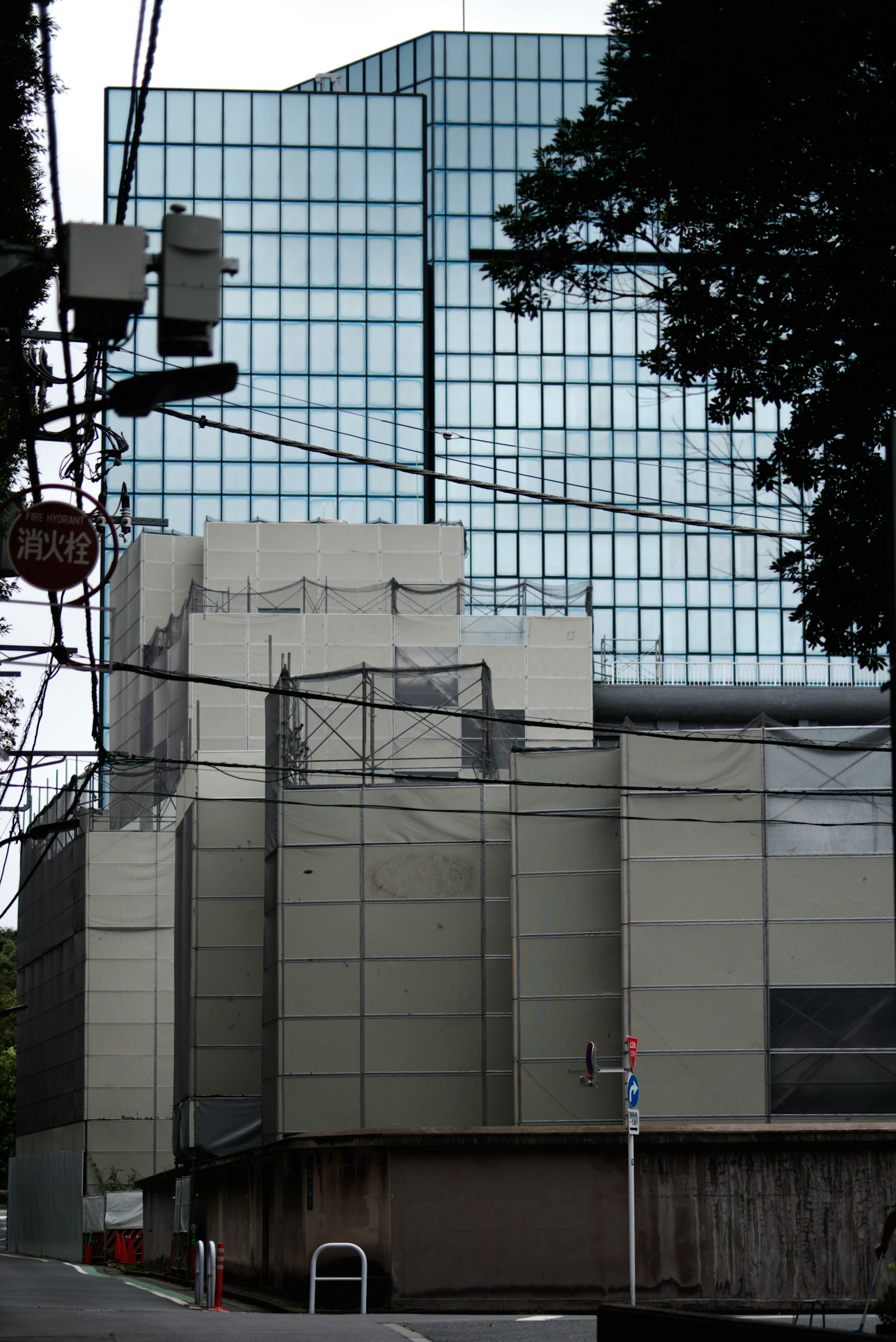 Paesaggio urbano con un edificio a facciata di vetro e linee elettriche circostanti