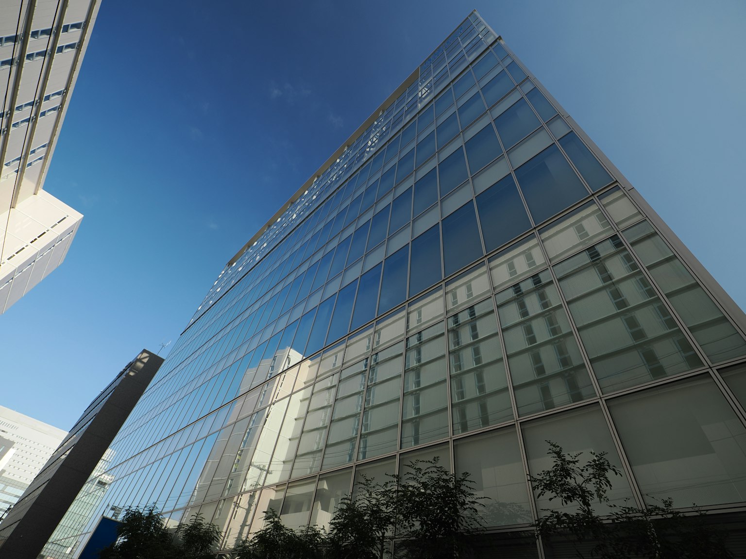 Bâtiment en verre moderne reflétant le ciel bleu