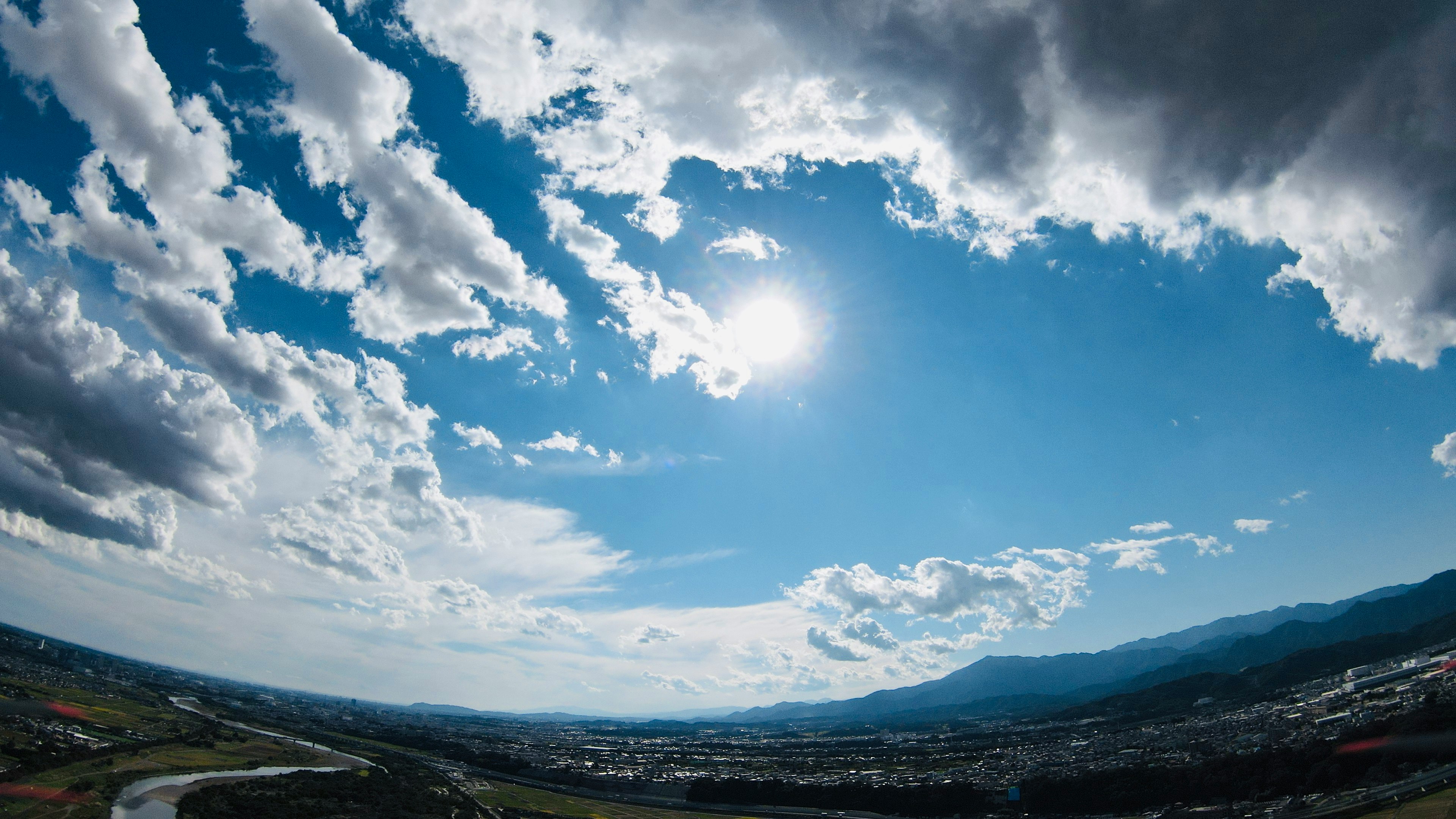 pemandangan pegunungan dan kota di bawah langit biru
