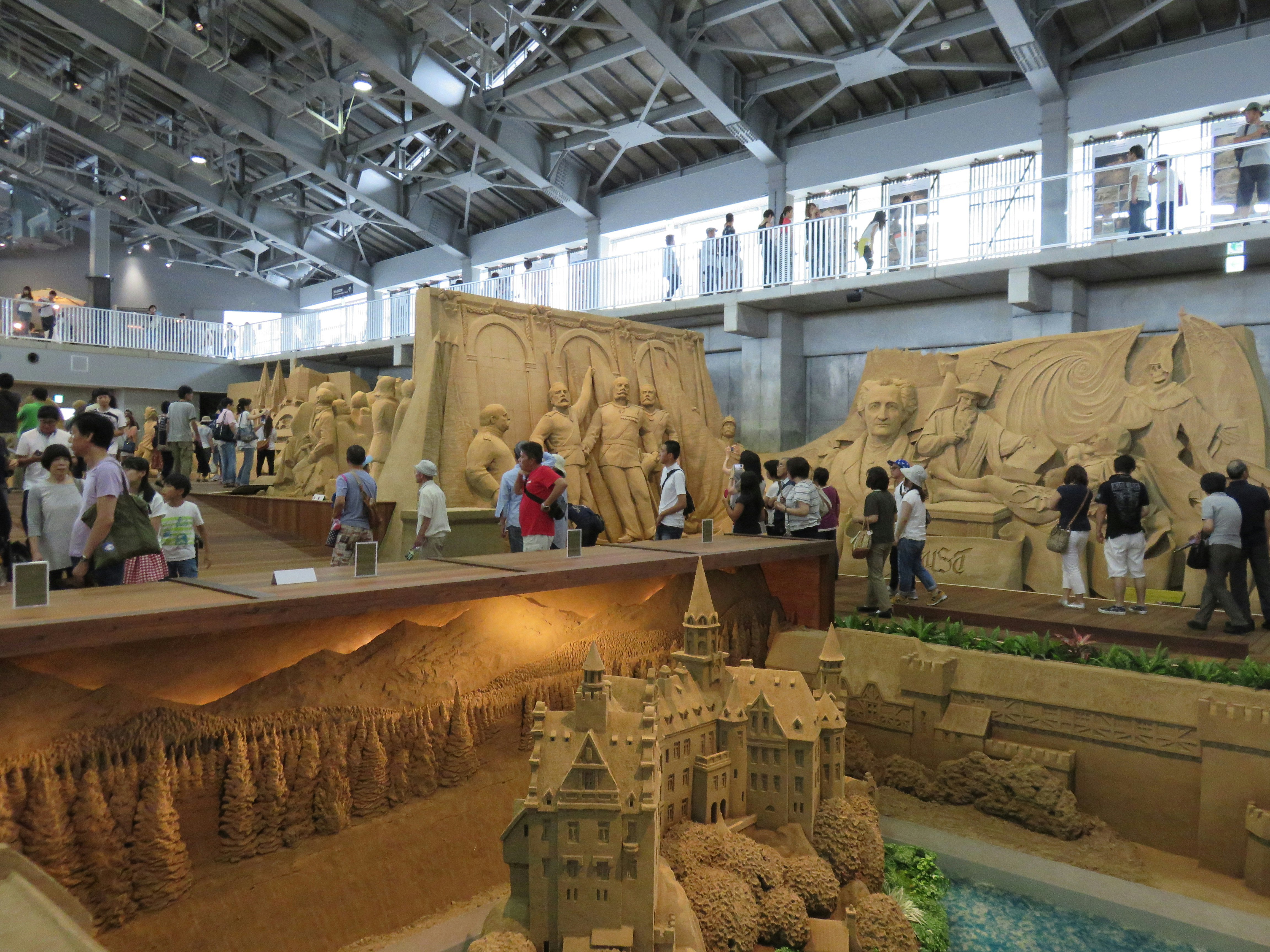 grande salle de musée avec modèles en sable et visiteurs