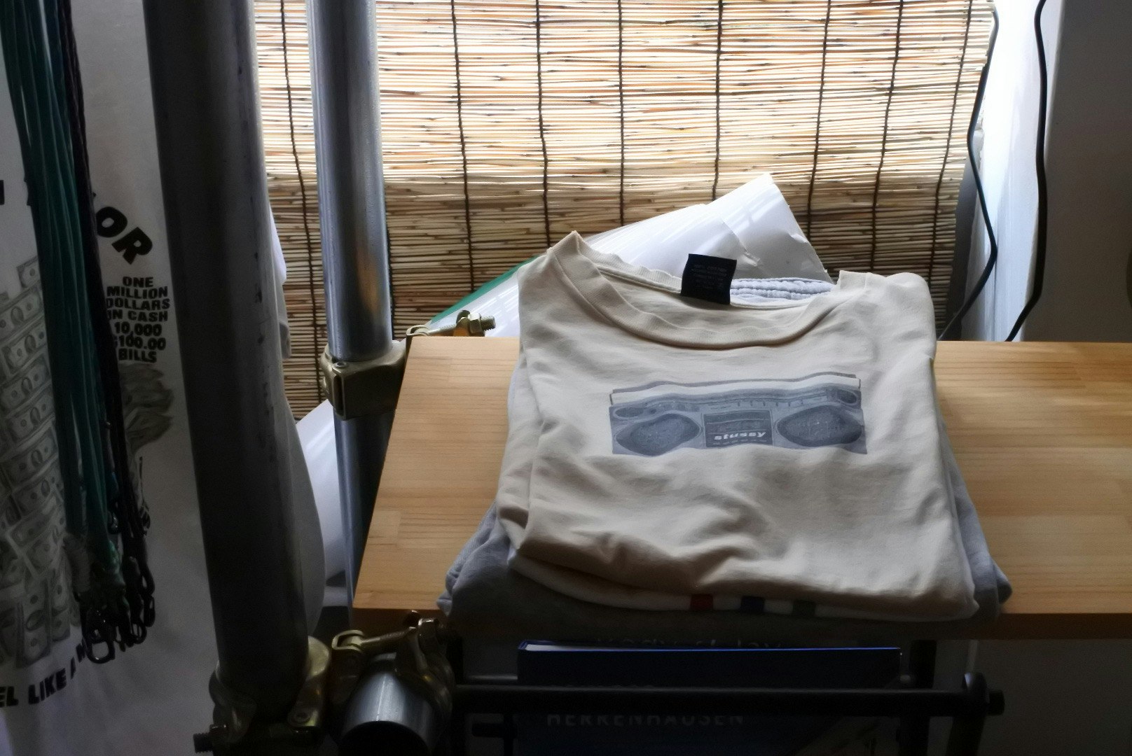 Folded STUSSY logo T-shirt placed on an indoor shelf