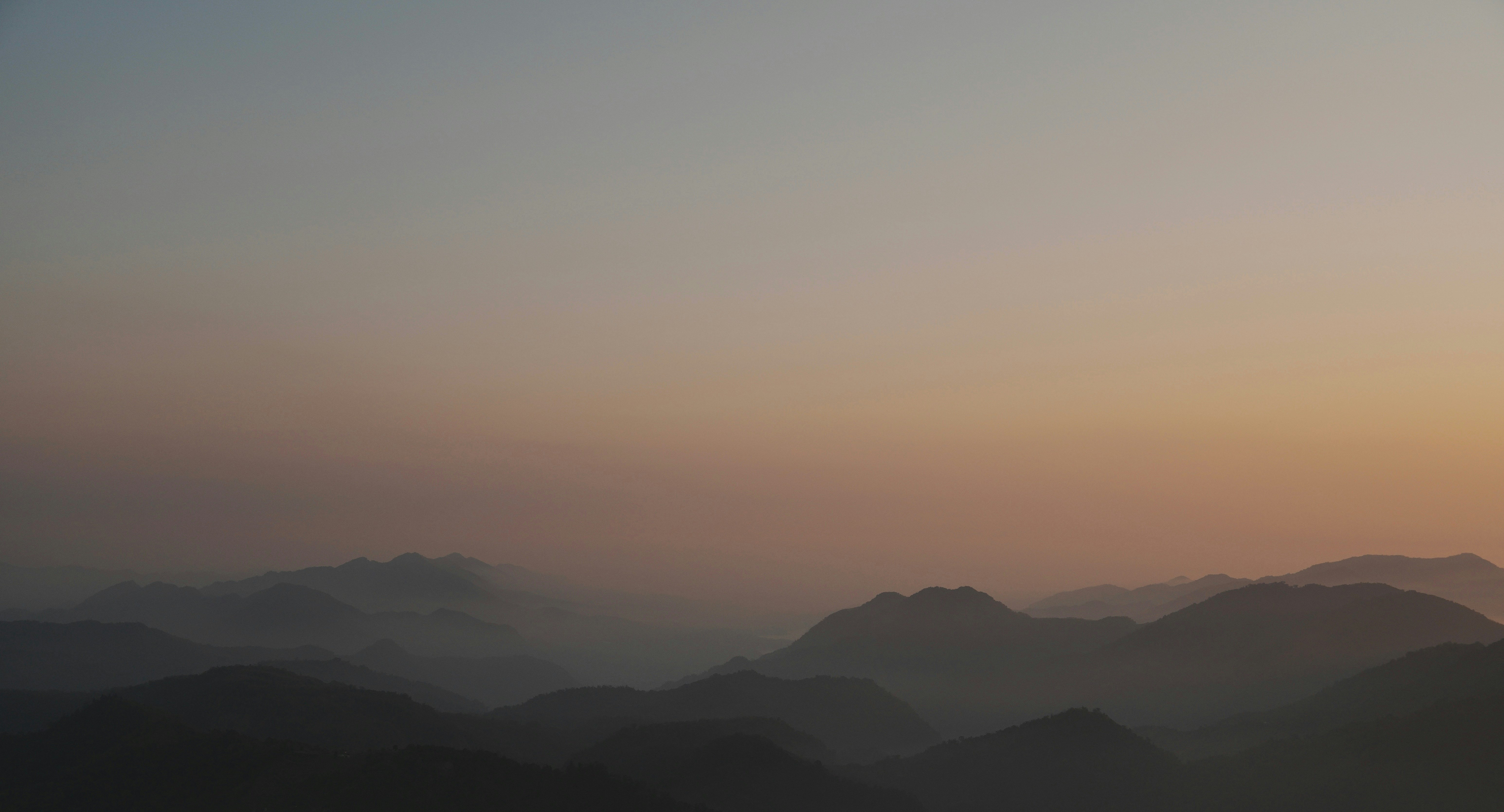 夕暮れの山並みが重なる大気の風景