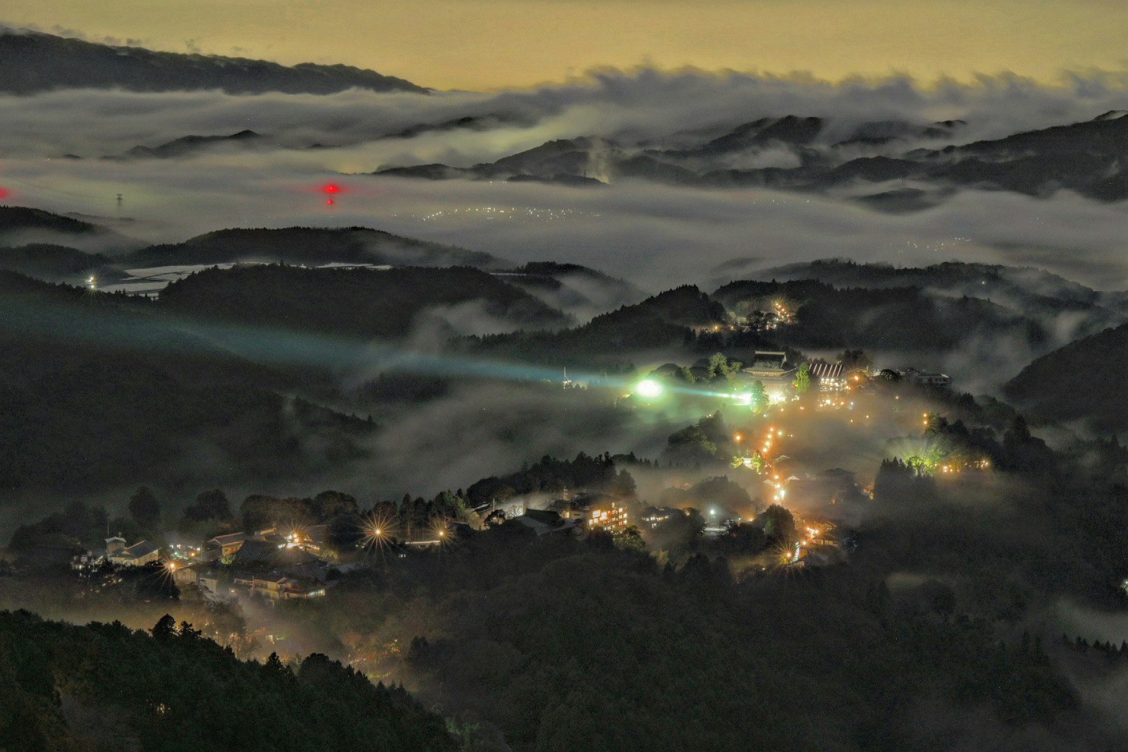 雲海に浮かぶ夜景の山あいの町並み
