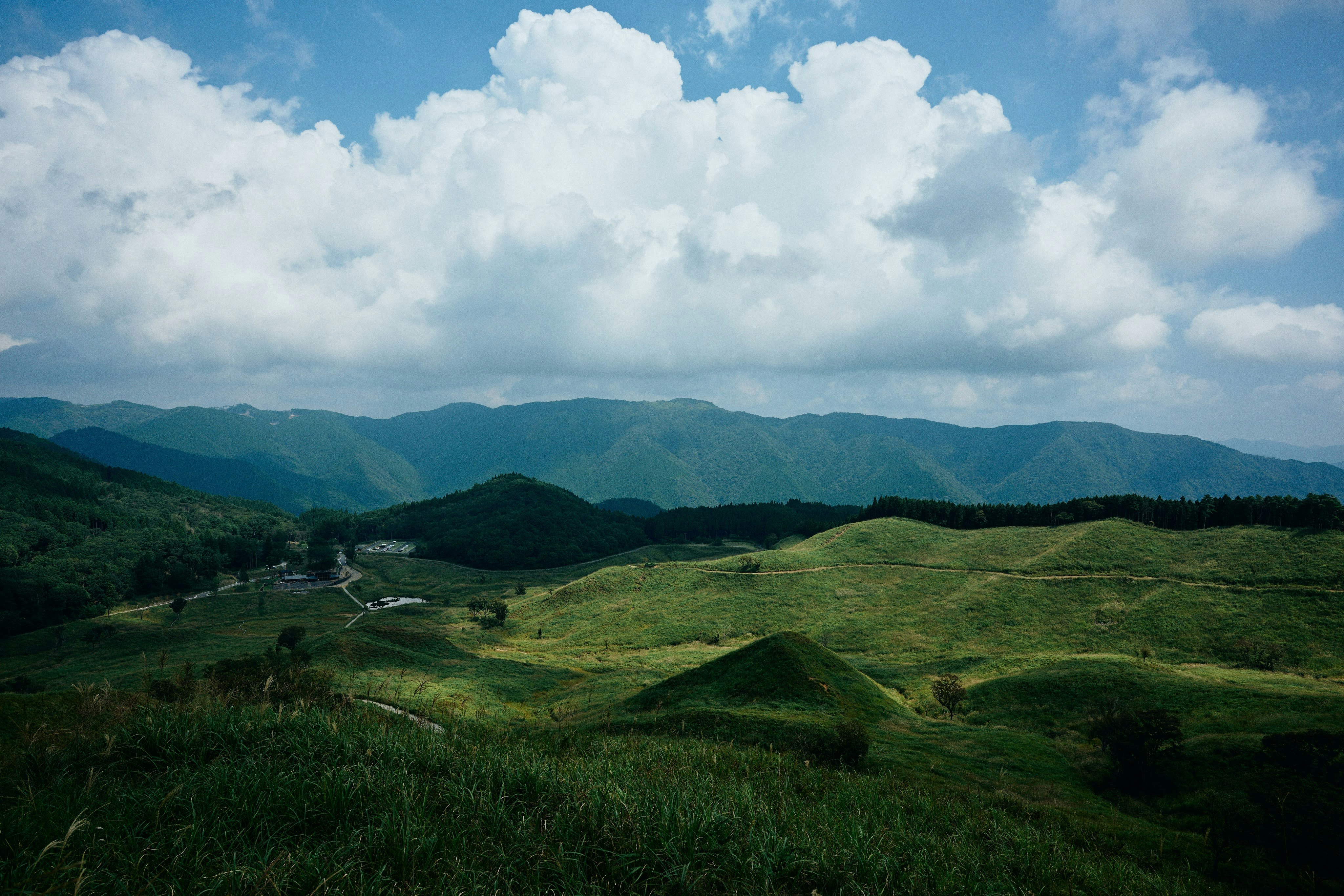 緑の丘陵と山並みが広がる自然風景