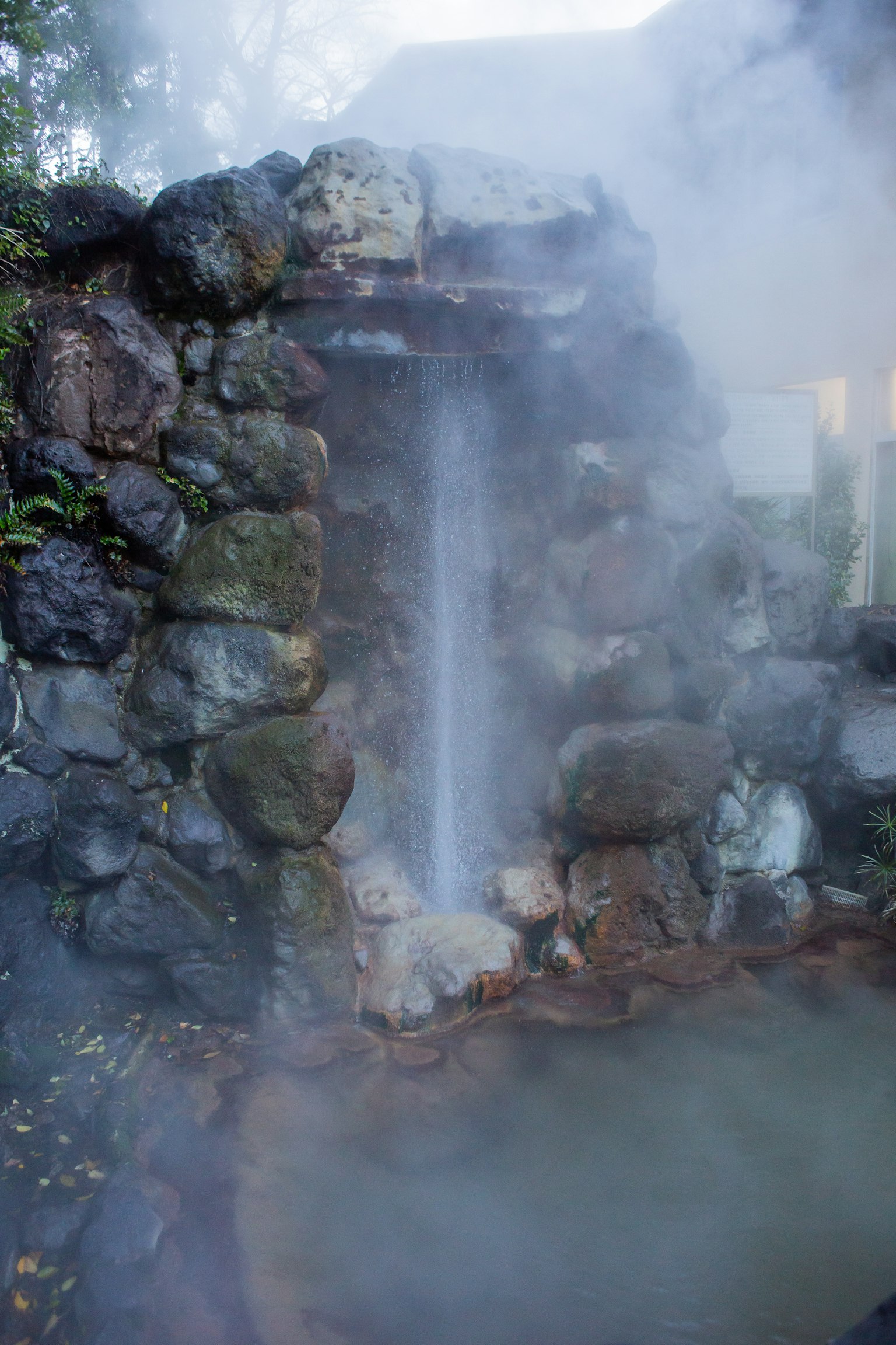 Scenic hot spring with steam and stone waterfall