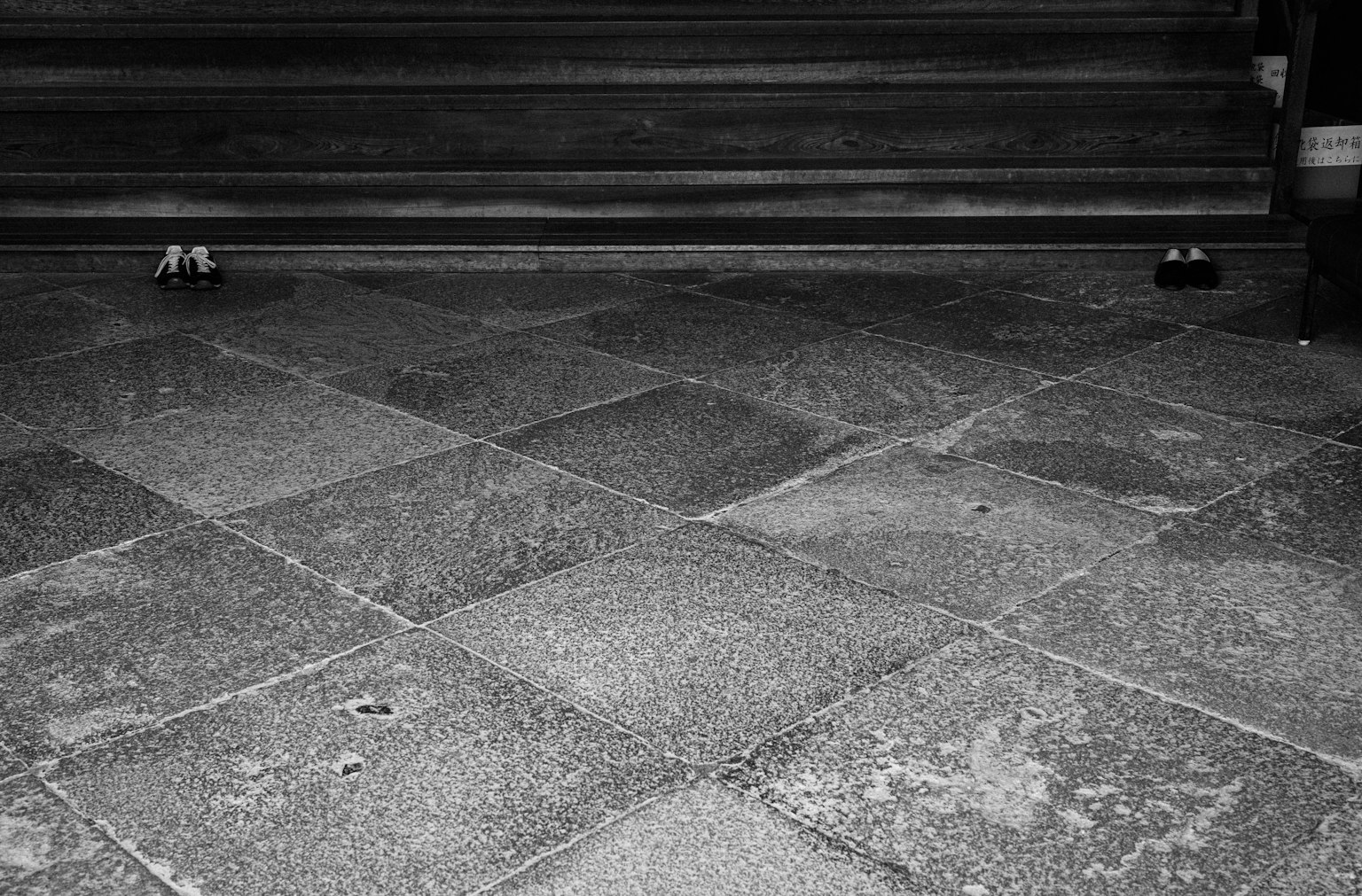 Photo en noir et blanc d'un sol en pierre devant des escaliers