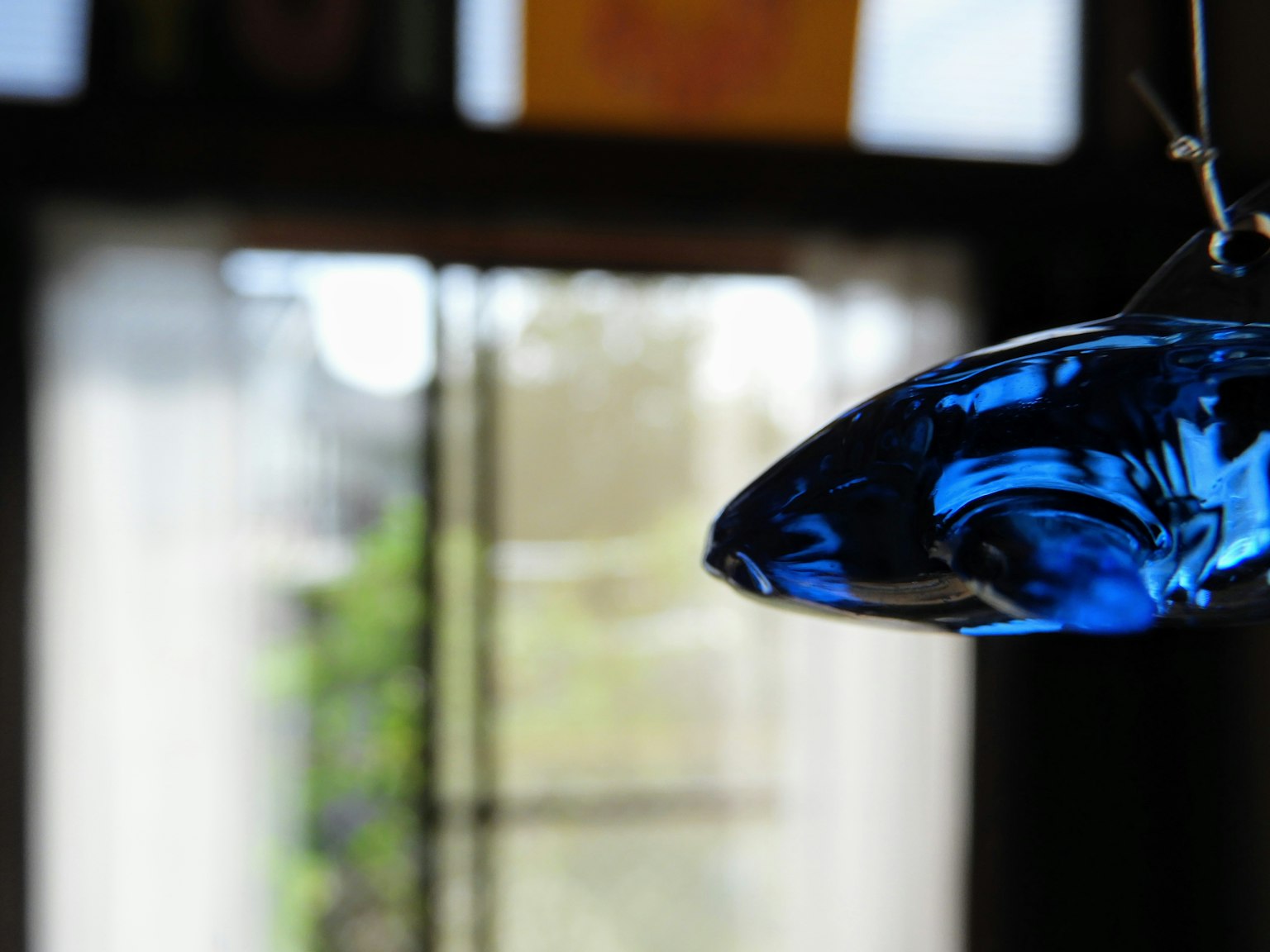 Interior de una habitación con una lámpara de vidrio azul colgante