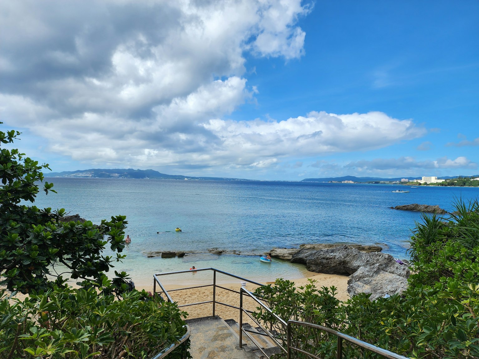 美丽的海滩景色蓝色海洋绿植和通往海岸的可见台阶
