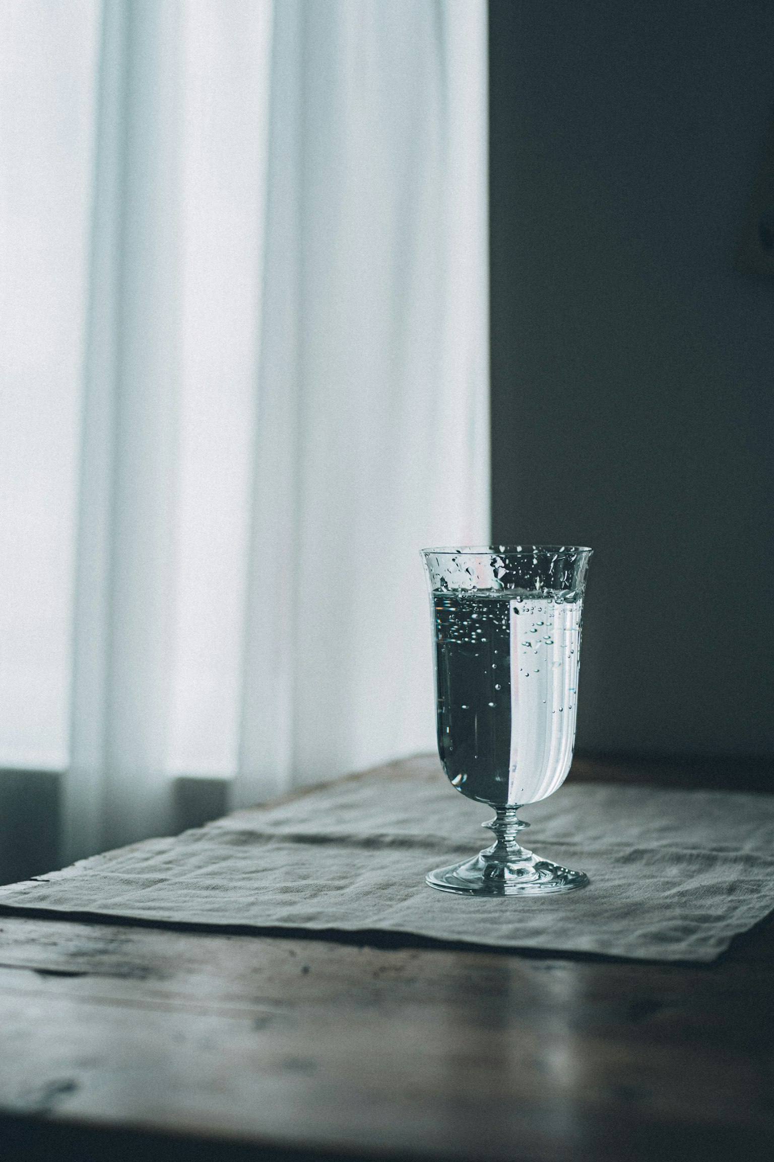 一个装满水的水晶杯放在木桌上,宁静的室内环境
