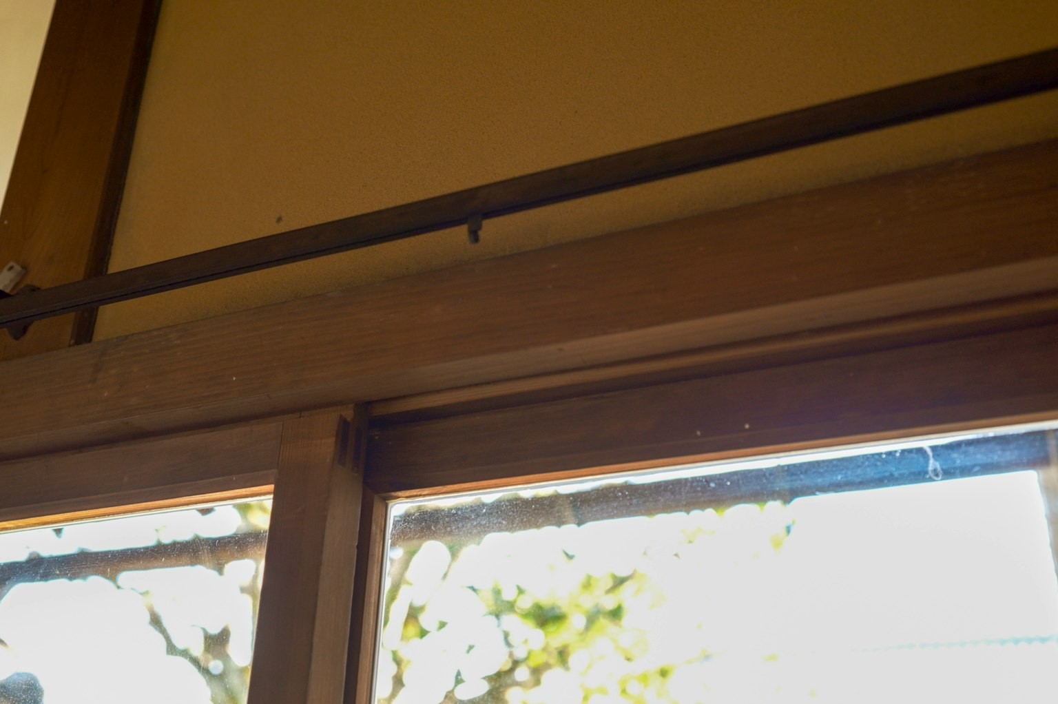 Wooden window blinds and metal rail above the window