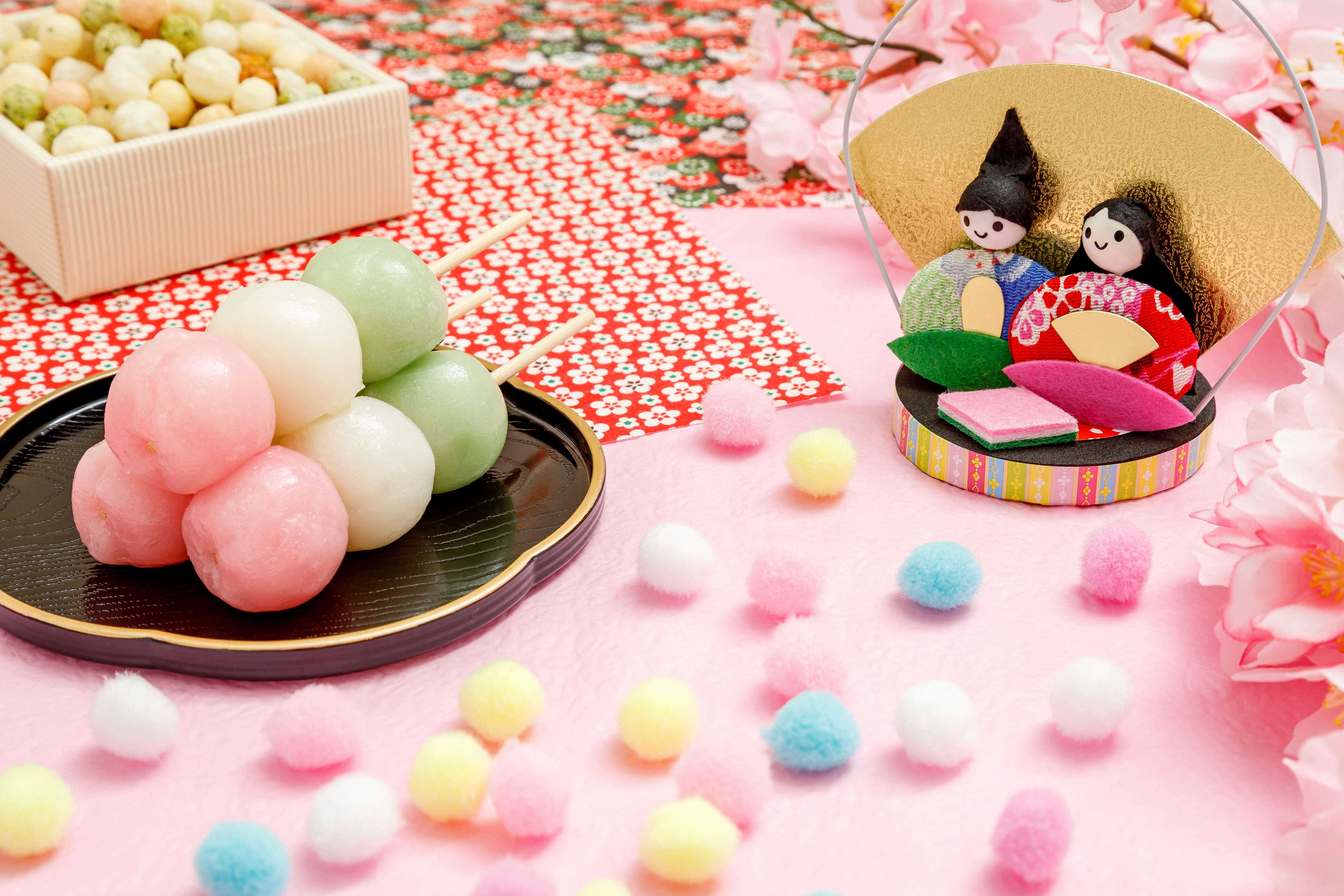 ピンクの布とカラフルなポンポン、和菓子の並ぶ甘い雰囲気