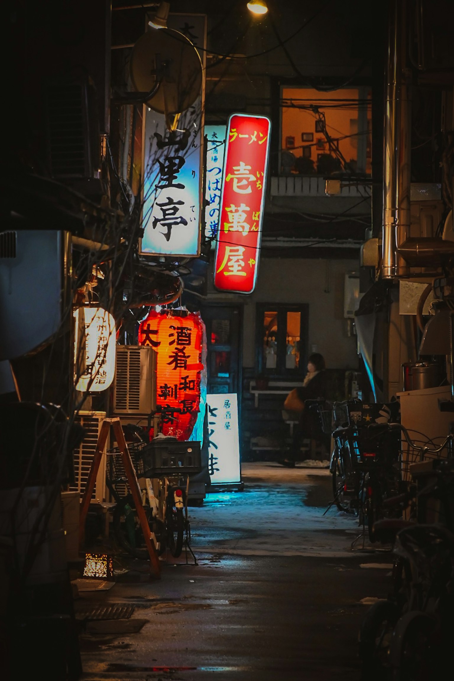 Ngõ hẹp được chiếu sáng bởi các biển hiệu neon nhiều màu vào ban đêm