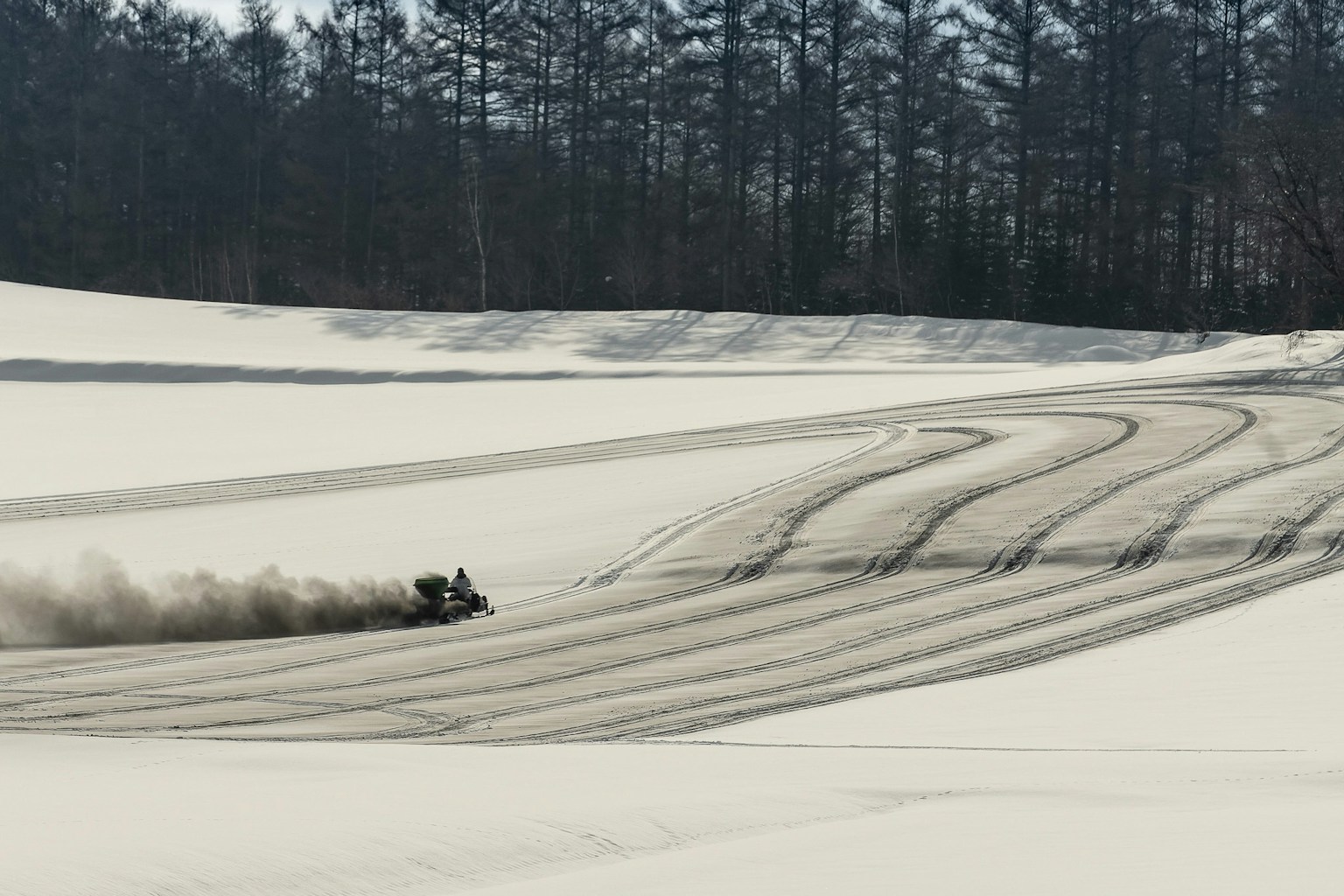 Motocicleta de nieve atravesando un paisaje nevado dejando huellas en la nieve