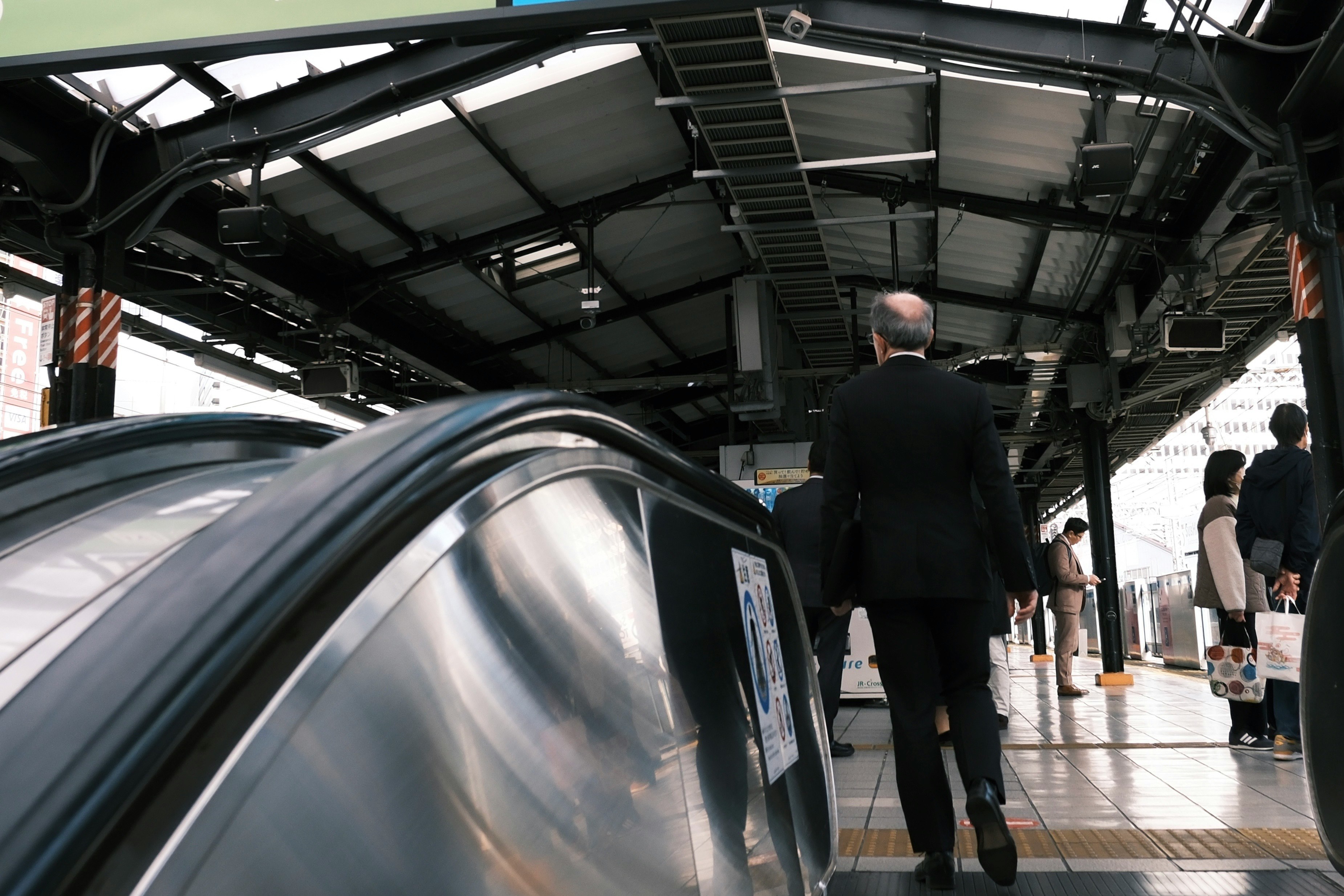 駅のホームで並ぶ電車と人々の行き交う通路