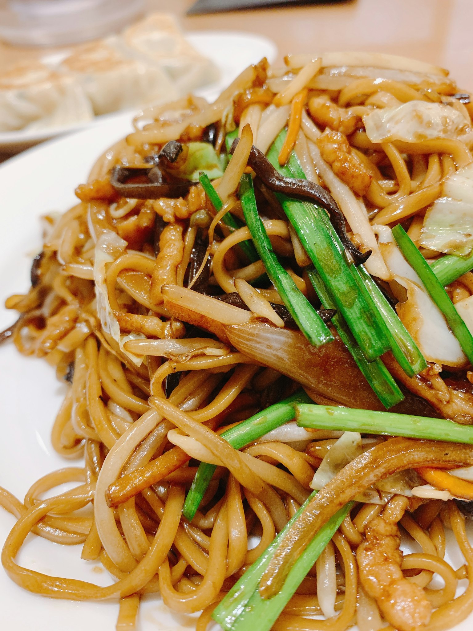 Cận cảnh mì xào trên đĩa trang trí bằng hành lá và các nguyên liệu khác
