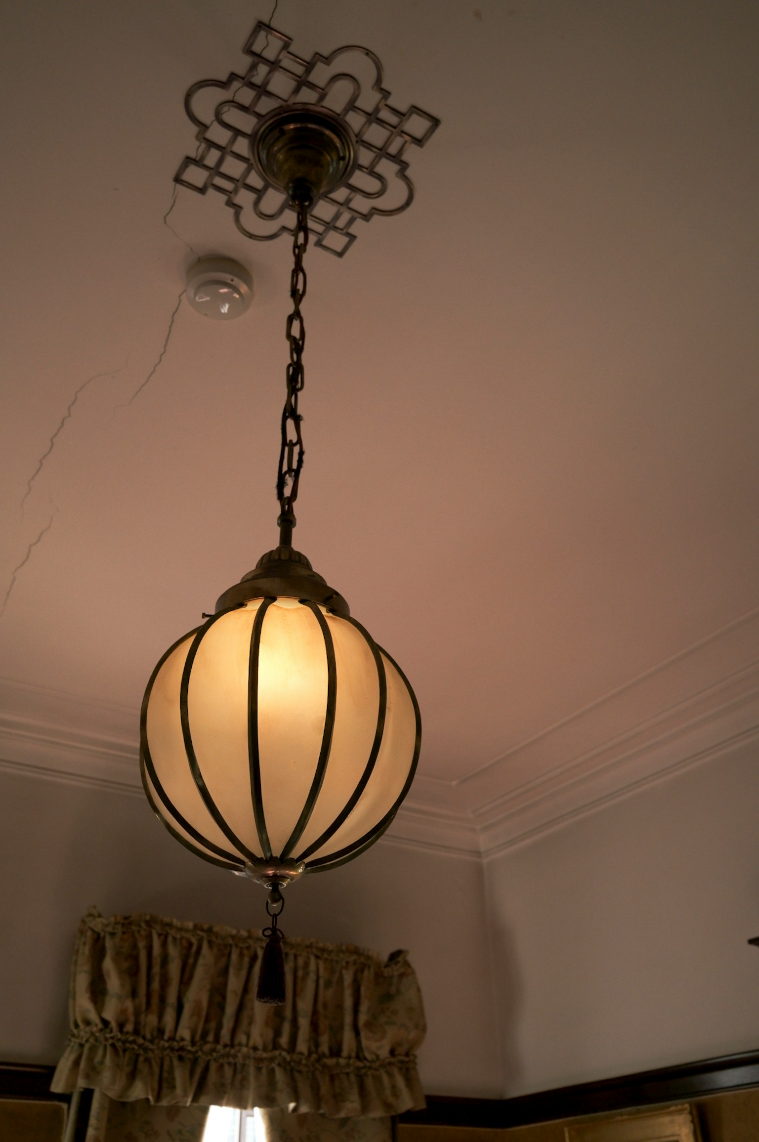 Una lampada a sospensione con un paralume bianco appeso al soffitto