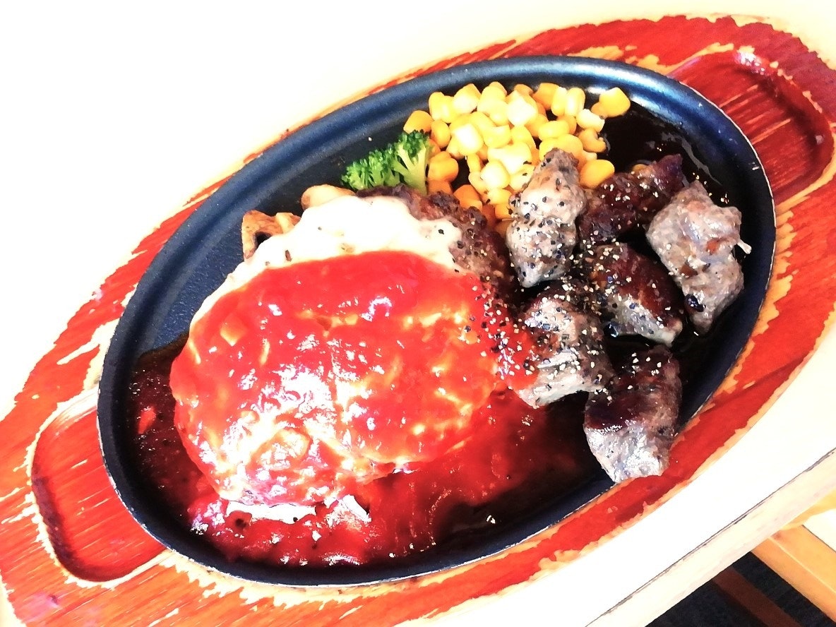 Oval plate of meat with ketchup sauce and corn