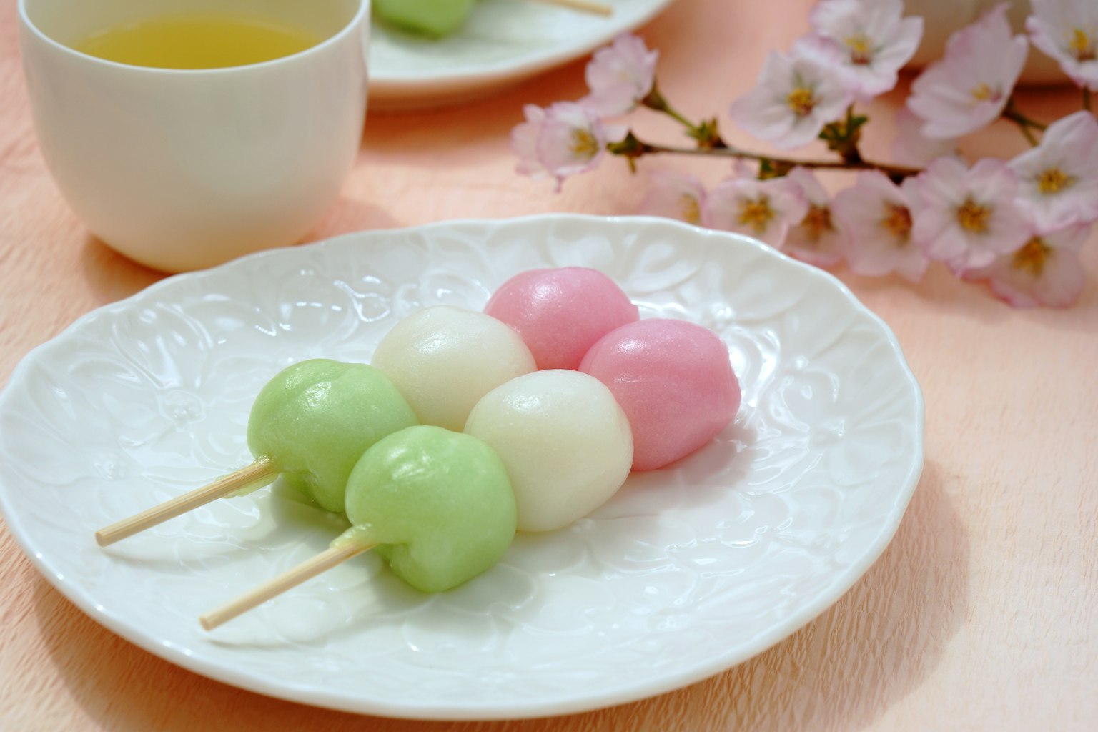 Un plato hermoso con dango colorido y flores de cerezo
