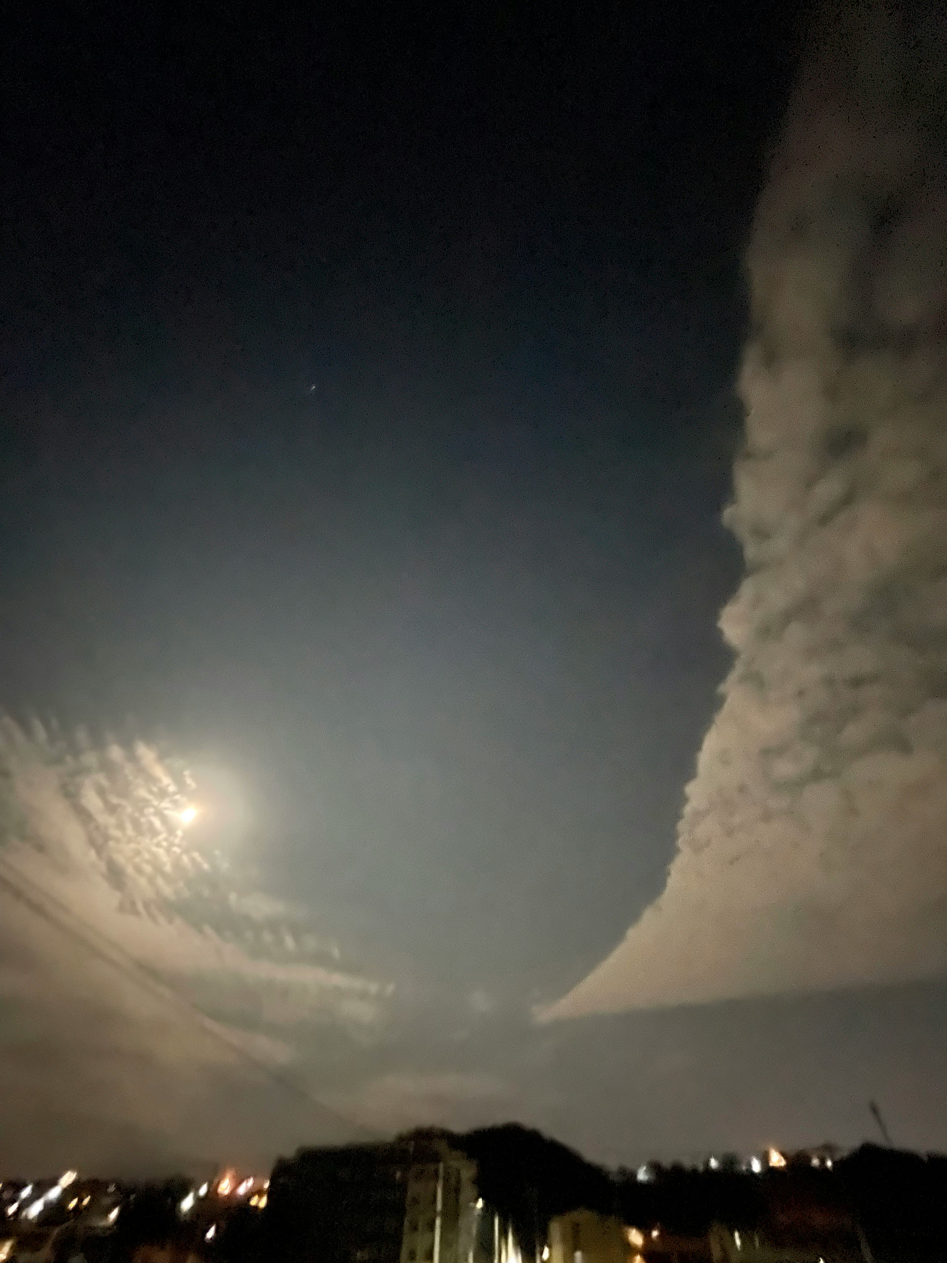 夜空に浮かぶ月と雲のコントラストが美しい景色