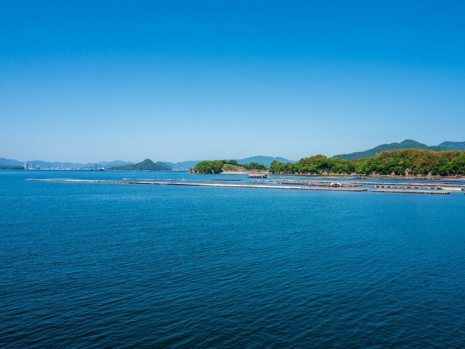 Vista escénica del mar azul tranquilo bajo un cielo despejado con islas verdes