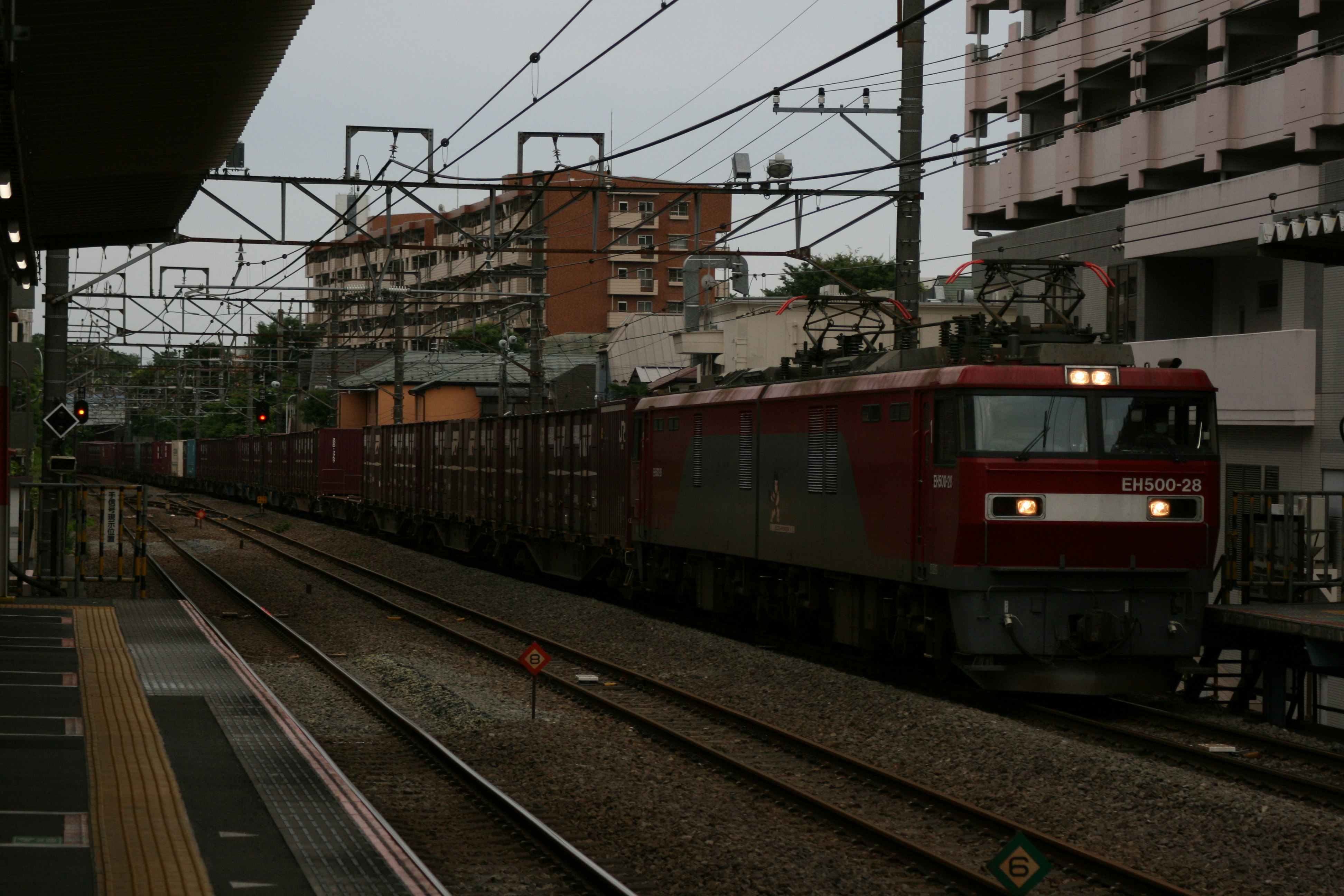 線路を走る赤い電車のある駅のホーム風景