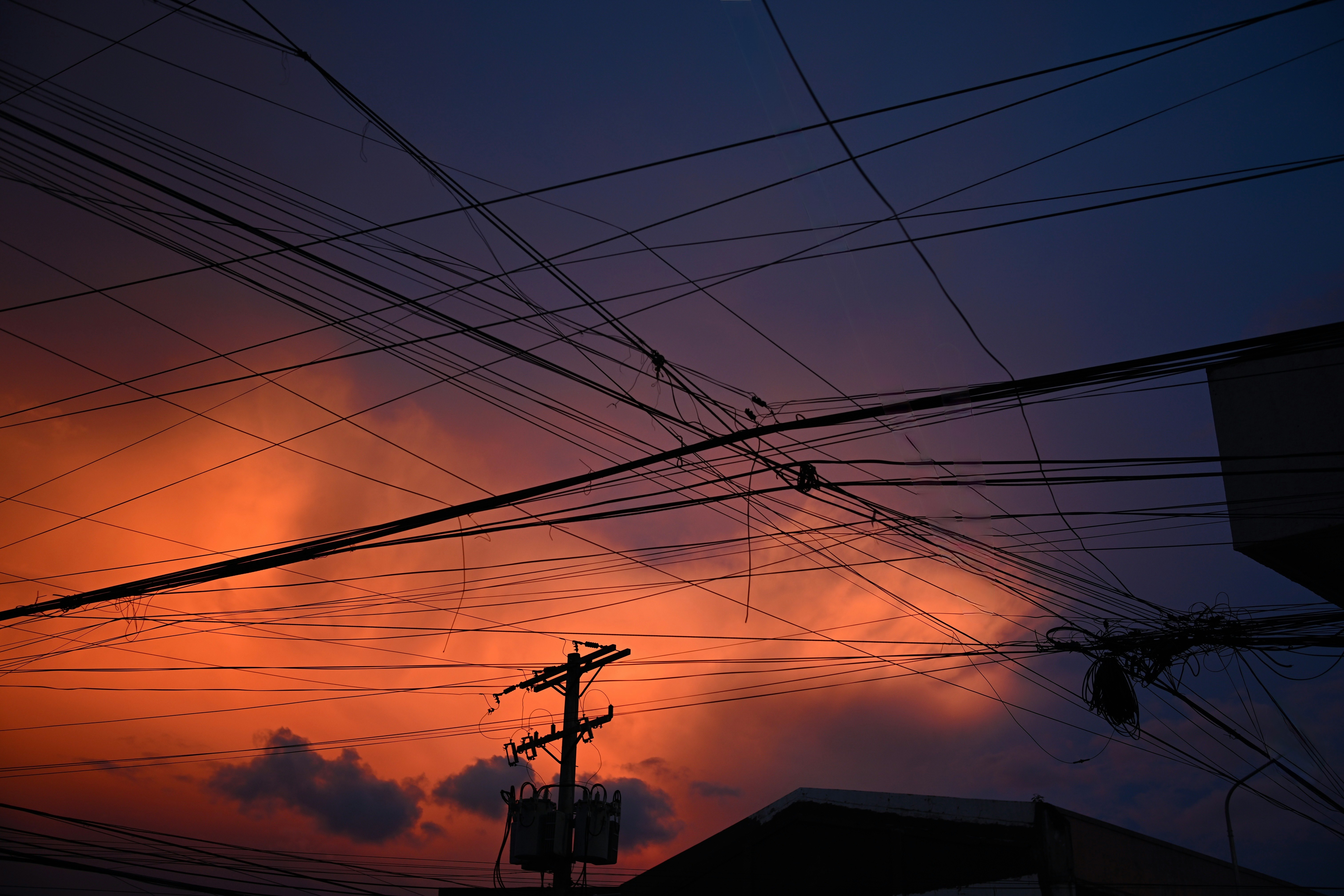 夕焼けの空と電線が交差する風景