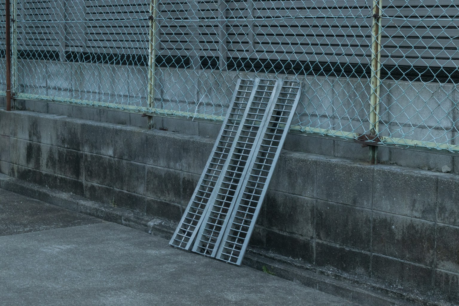 Paleta de metal gris apoyada contra una pared de concreto