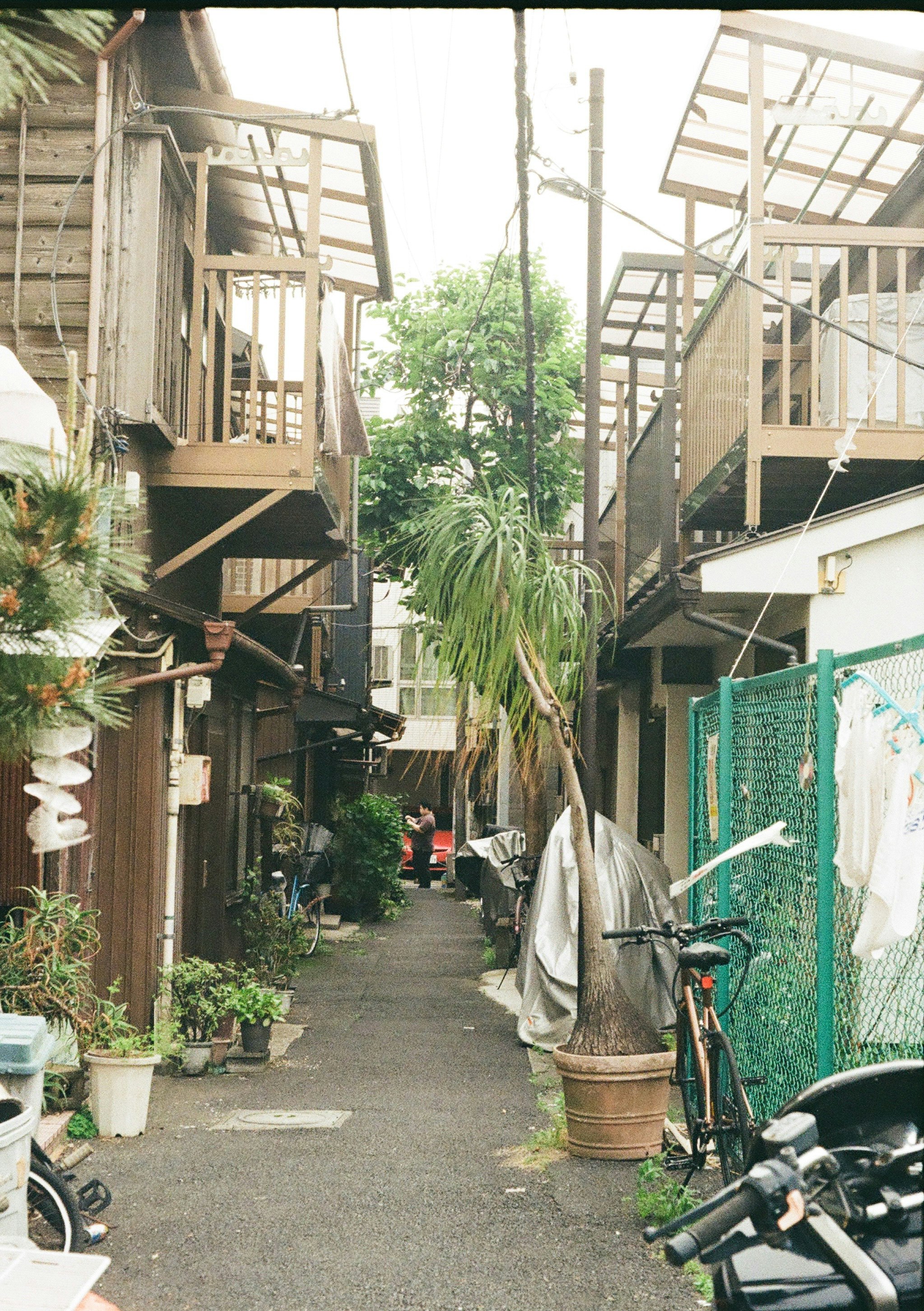路地に並ぶ木造の建物と自転車のある中庭