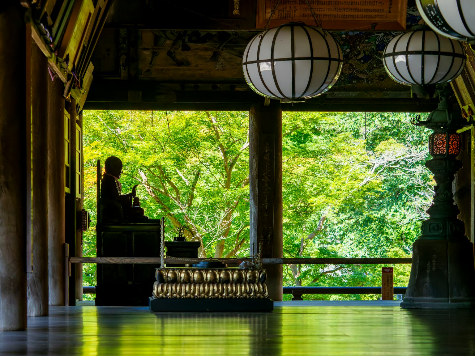 Intérieur de temple serein avec une statue et des lanternes sur fond vert