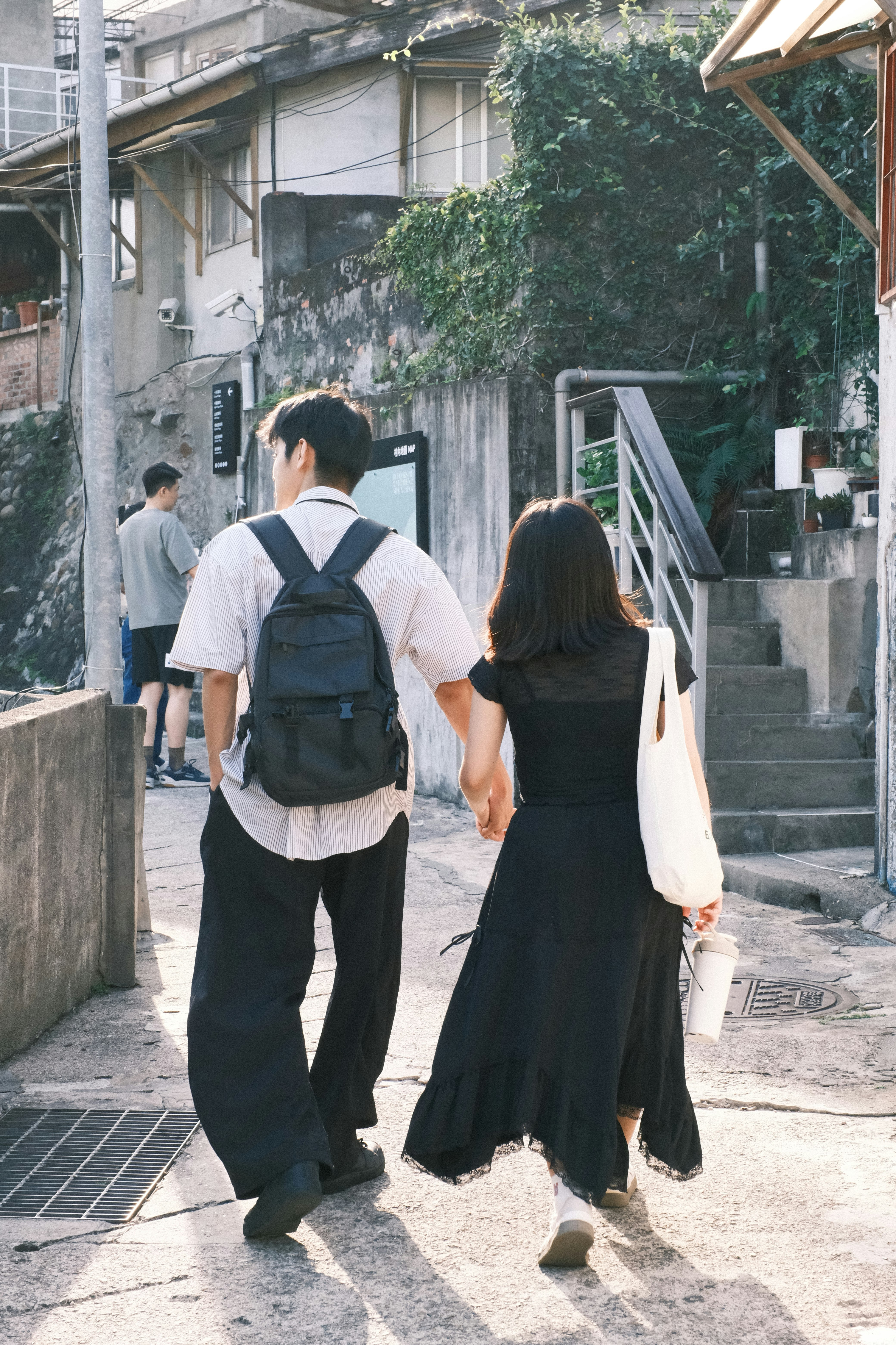 路地の階段に向かう旅行者の後ろ姿