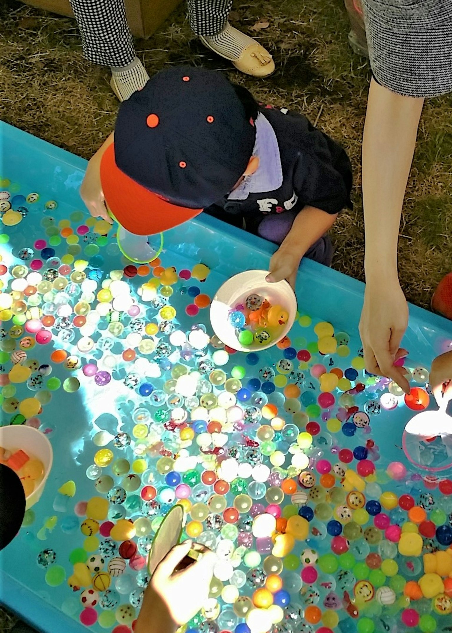 一個孩子在水中玩五顏六色的玻璃球