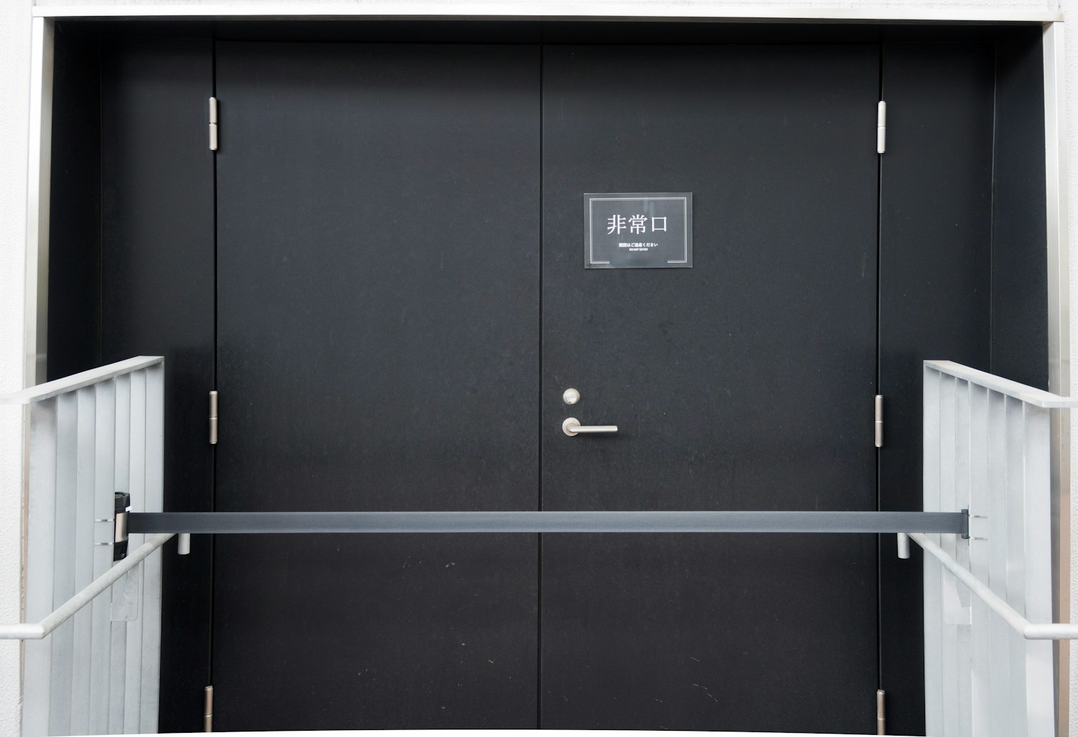Image of a black door with a railing