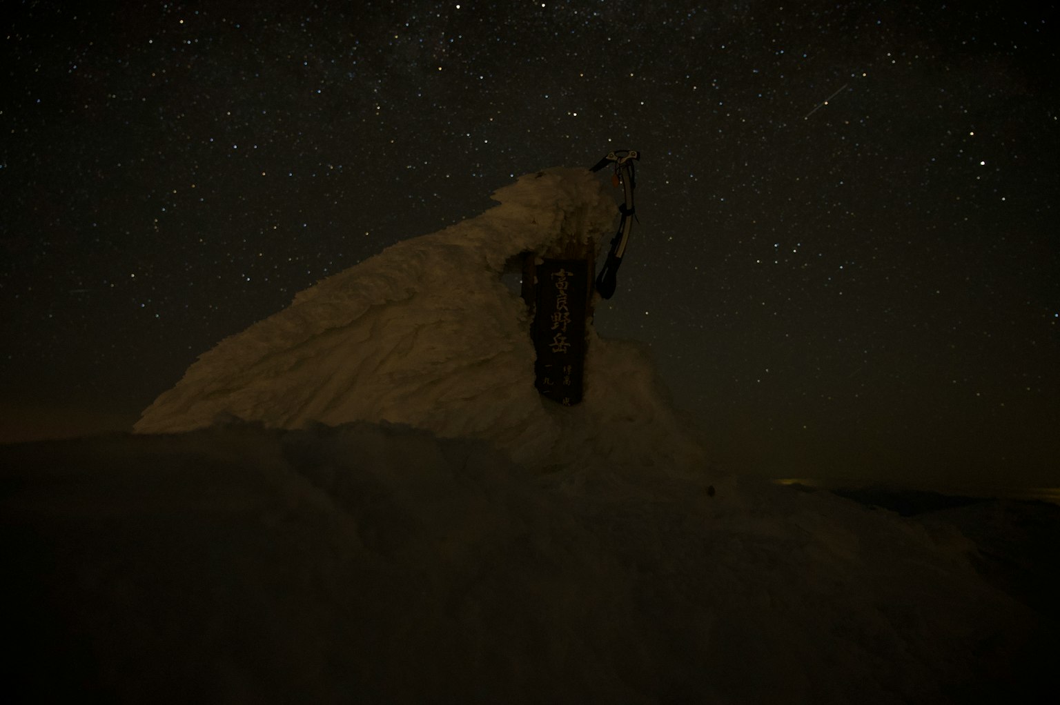 Silhouette d'une montagne enneigée sous un ciel étoilé