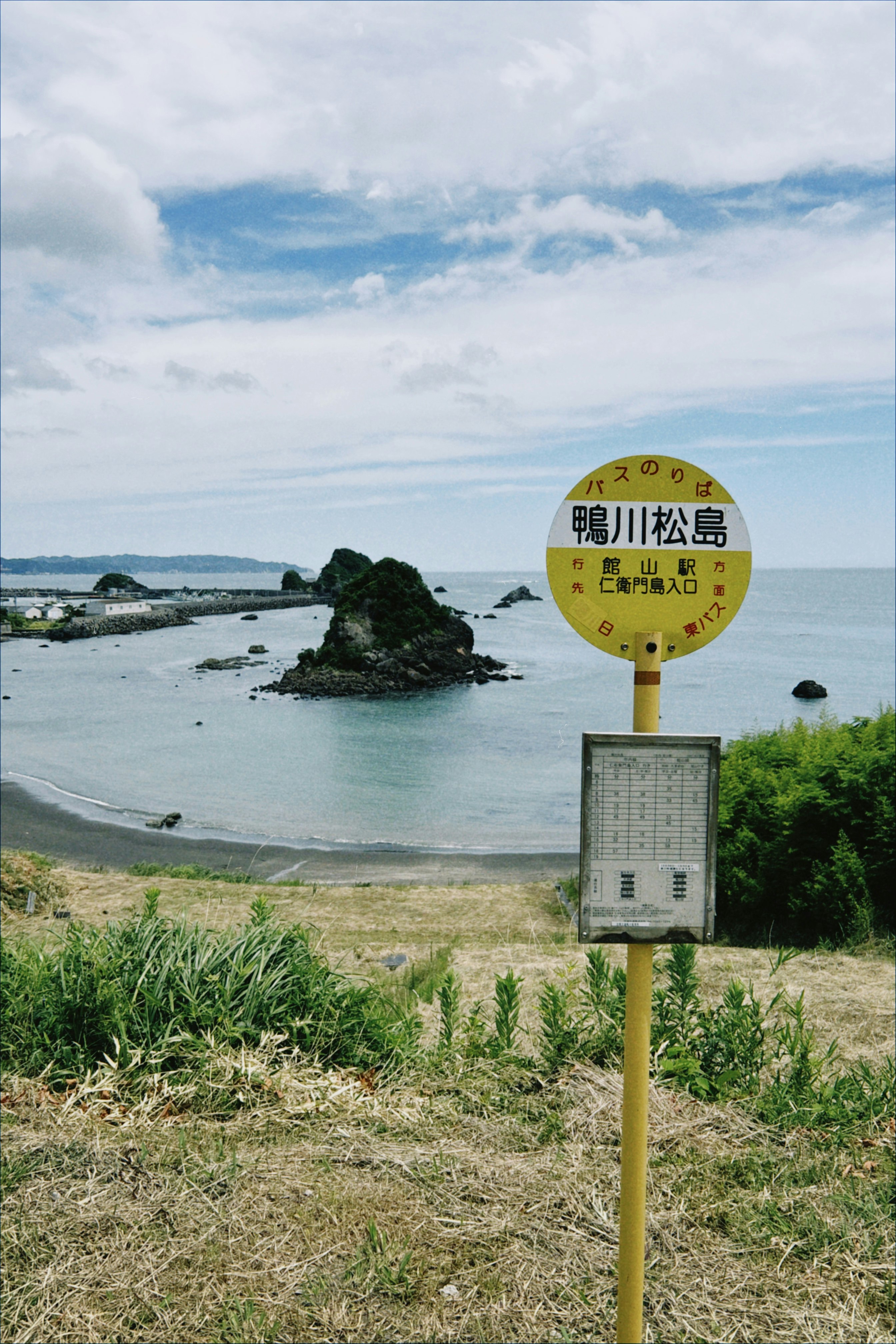 海辺の岩と砂浜、案内標識のある景色