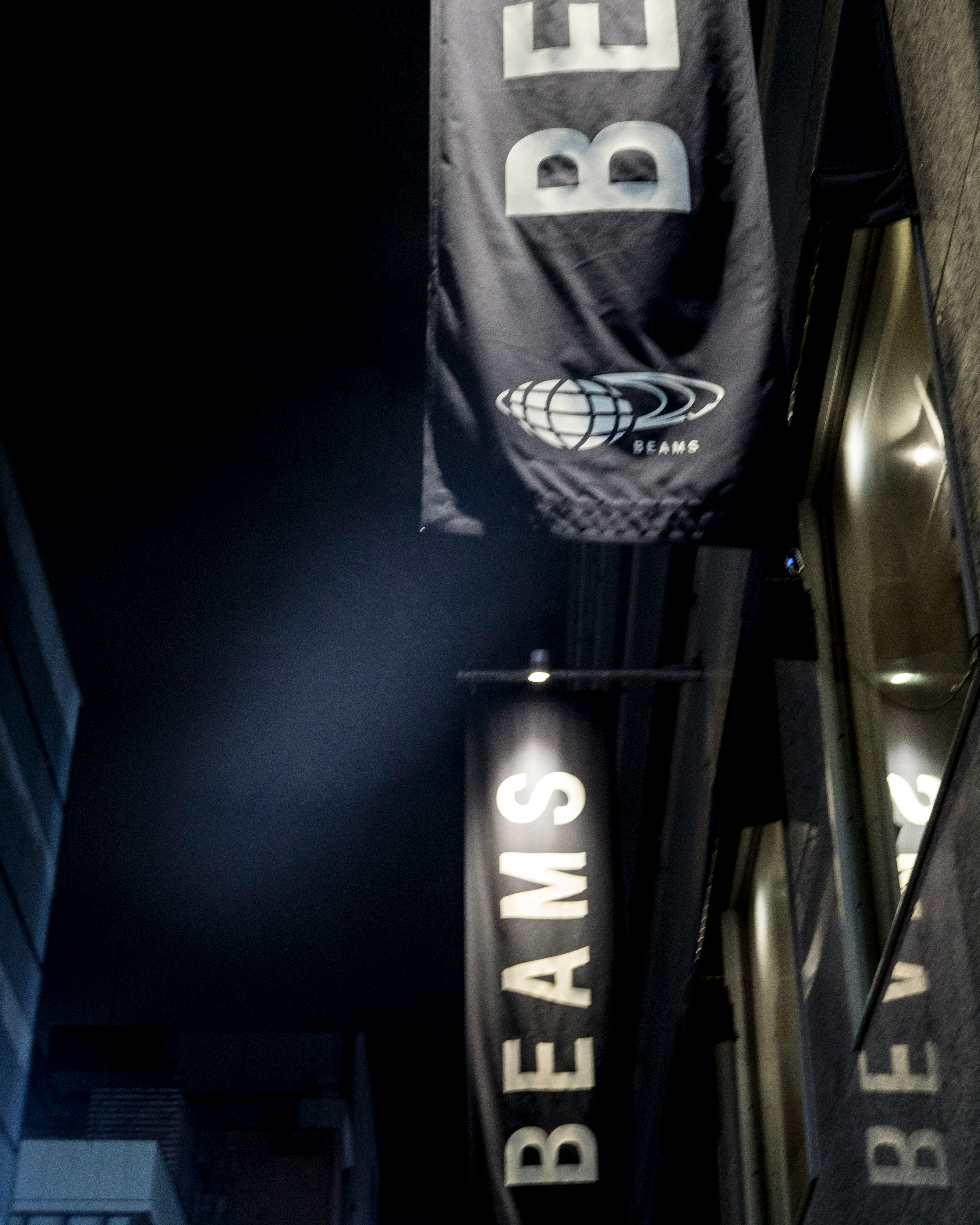 Night alley banner with the “BEAMS” logo and signage